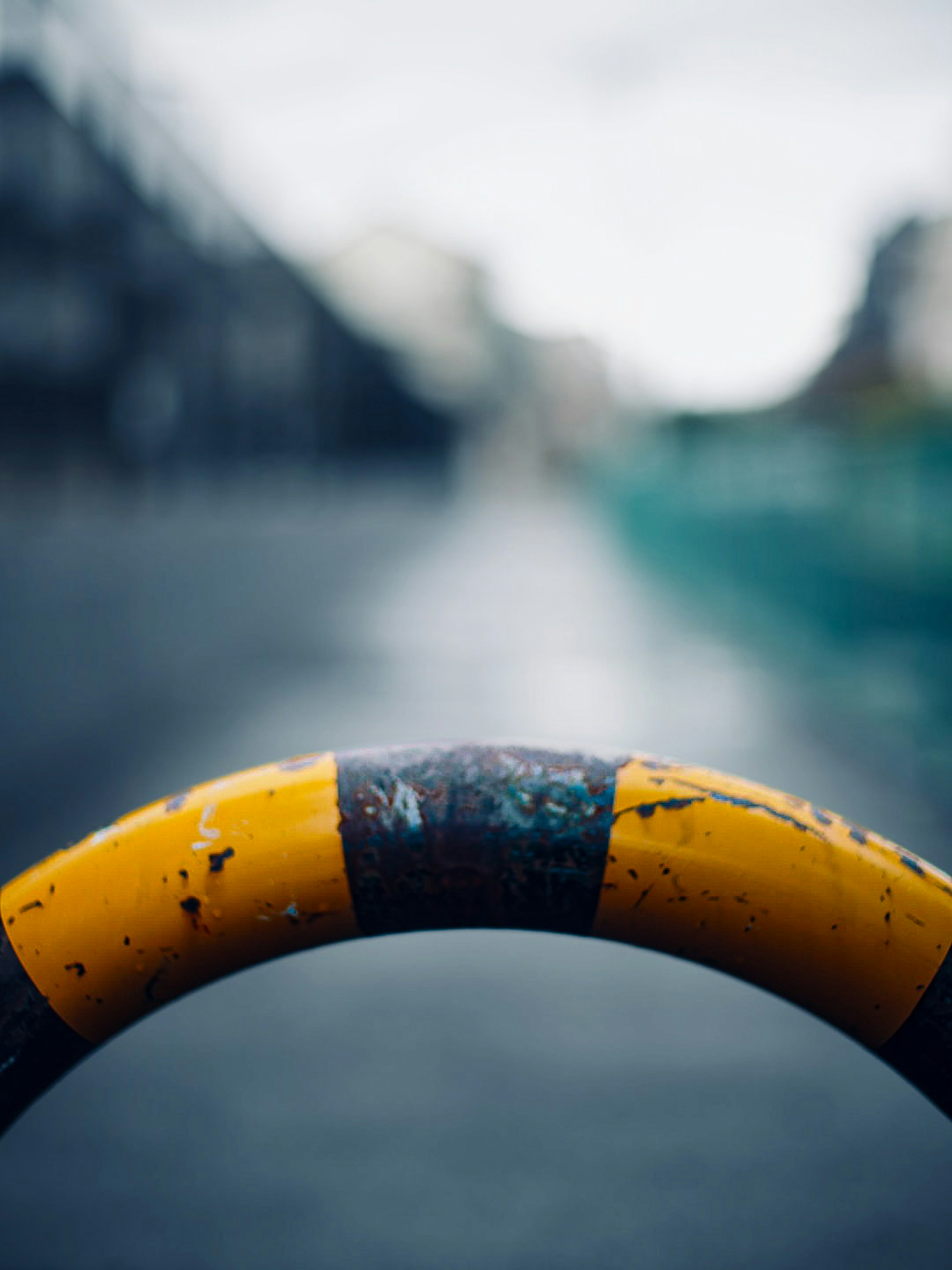 Close-up of a yellow and black striped frame with a blurred city background