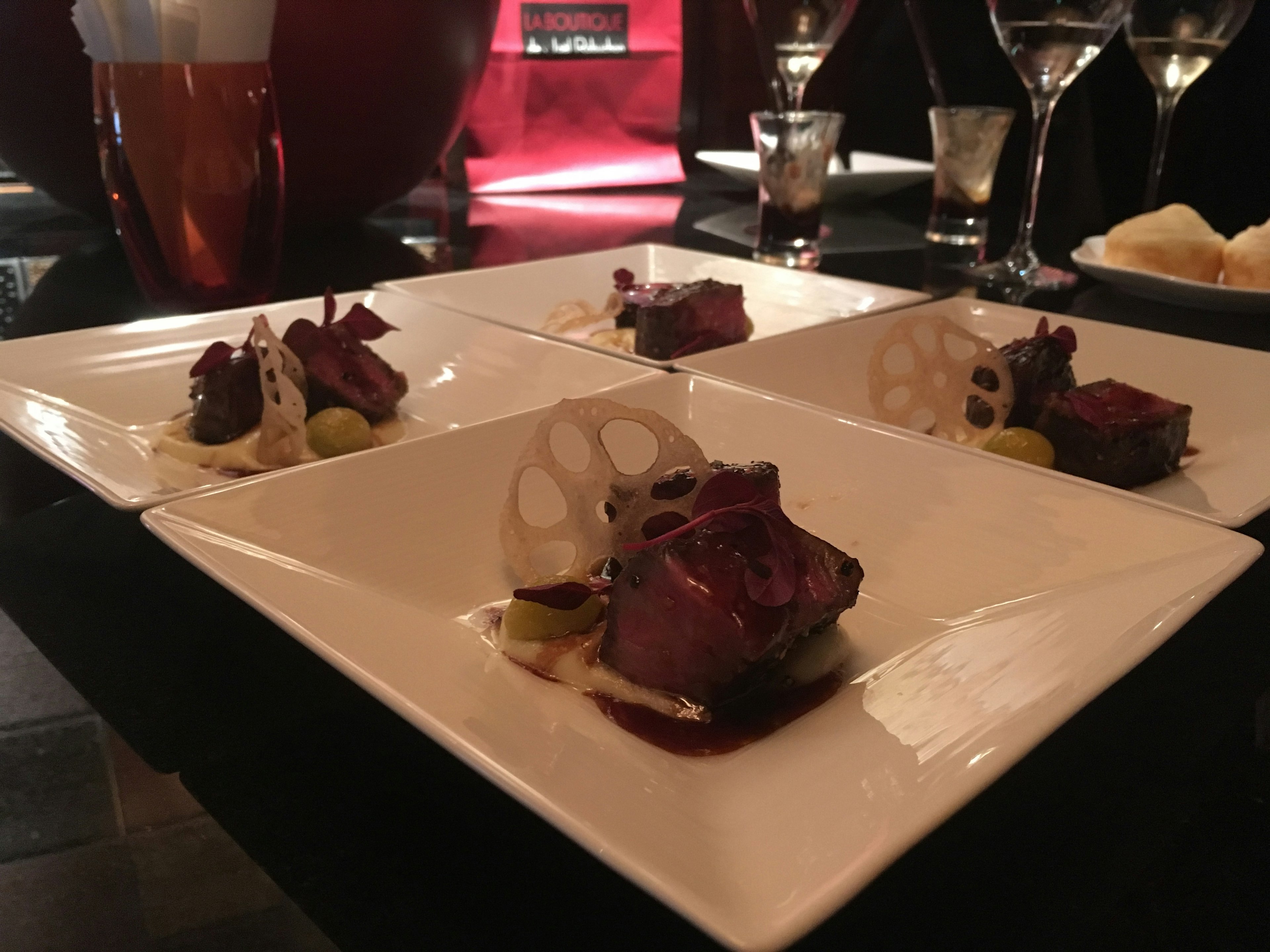 Plat gastronomique présenté sur des assiettes élégantes dans un restaurant à la lumière tamisée