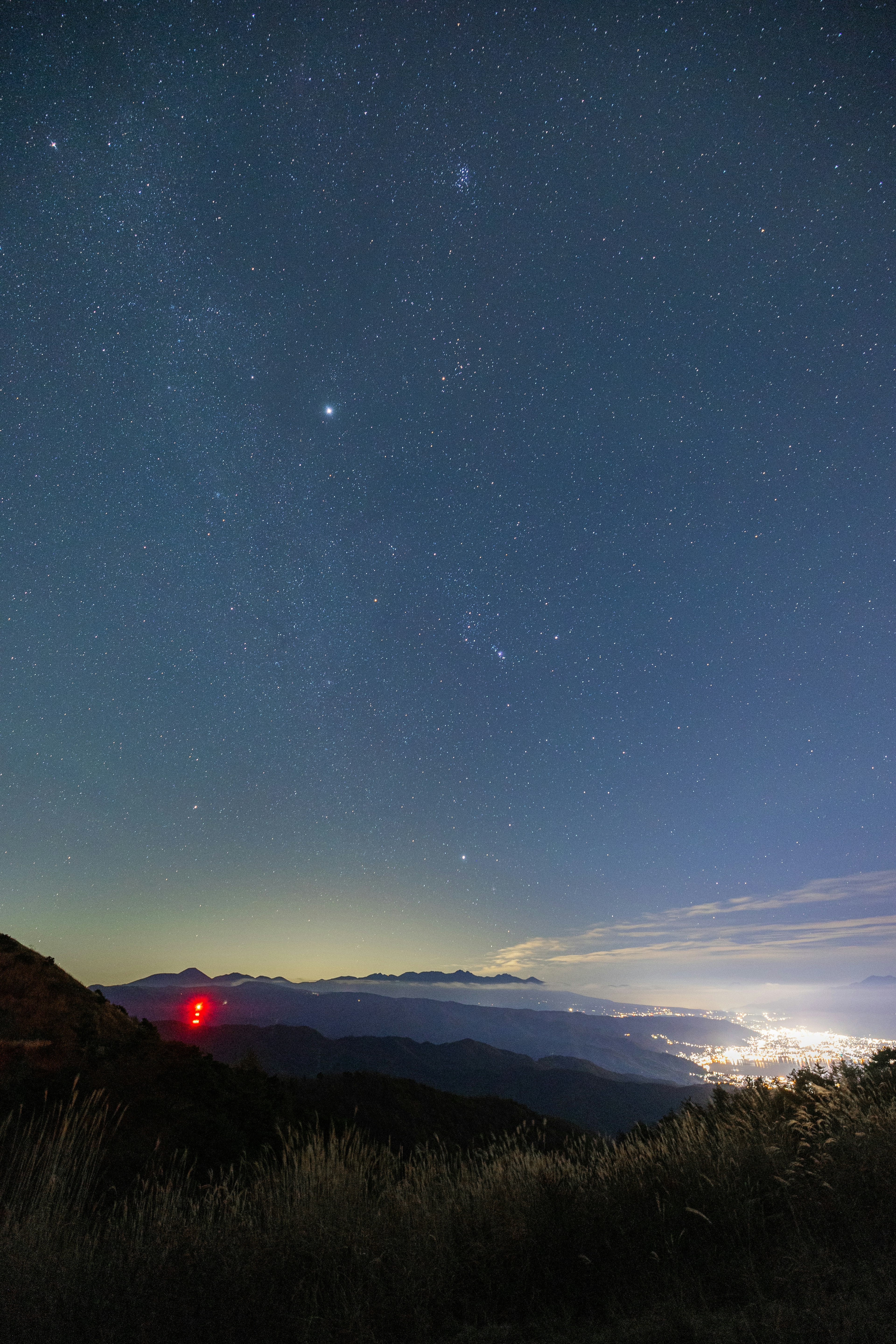 星空與山脈的夜景，映襯著紅色光芒