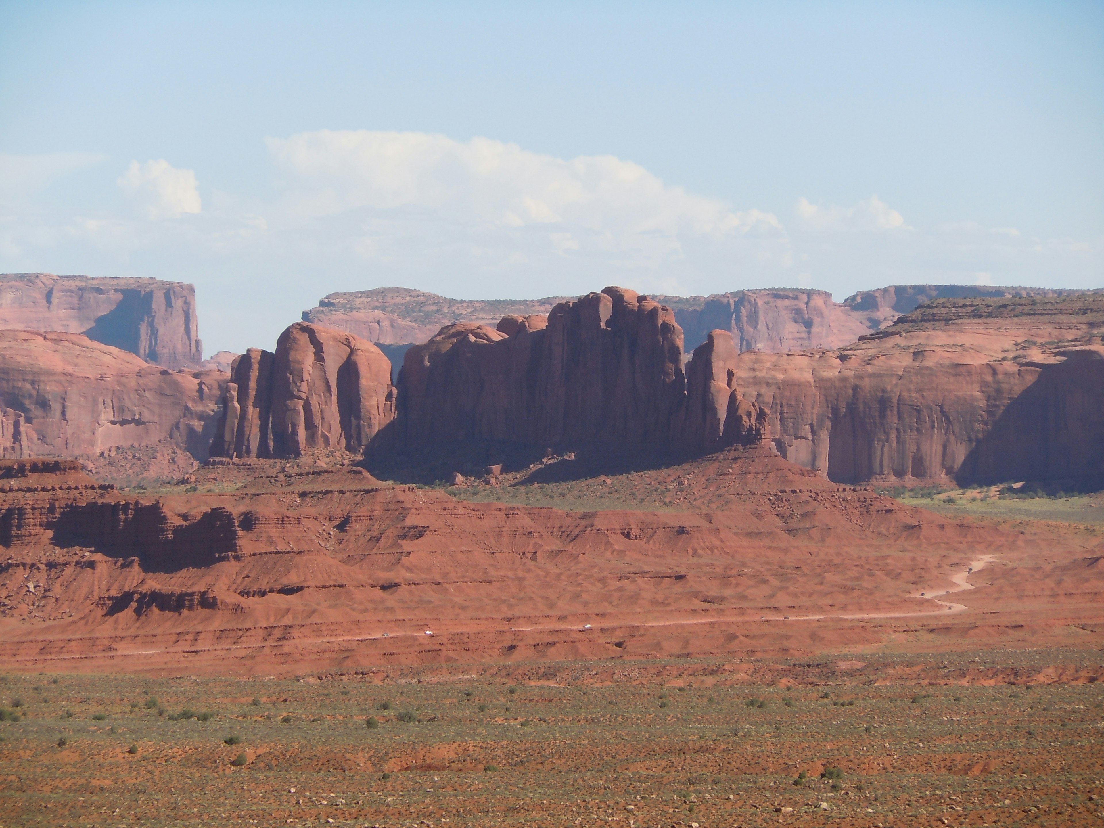 หินสีแดงของ Monument Valley ใต้ท้องฟ้าสีฟ้า