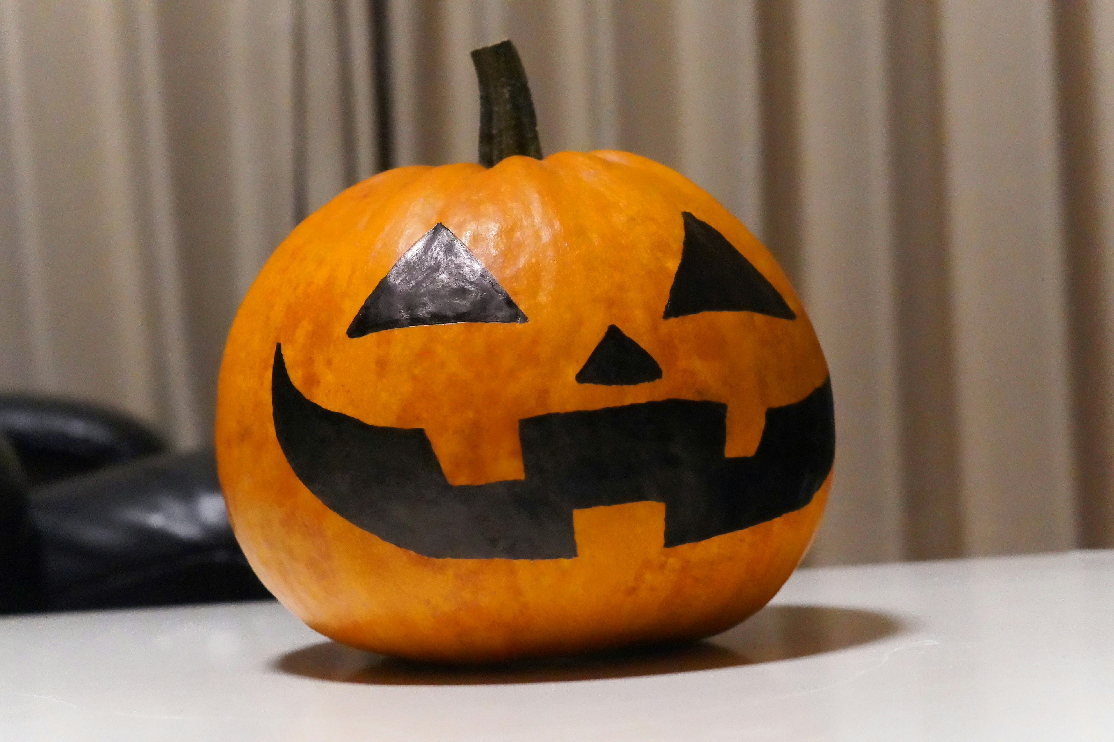 Orange Halloween pumpkin with a black face carved on it