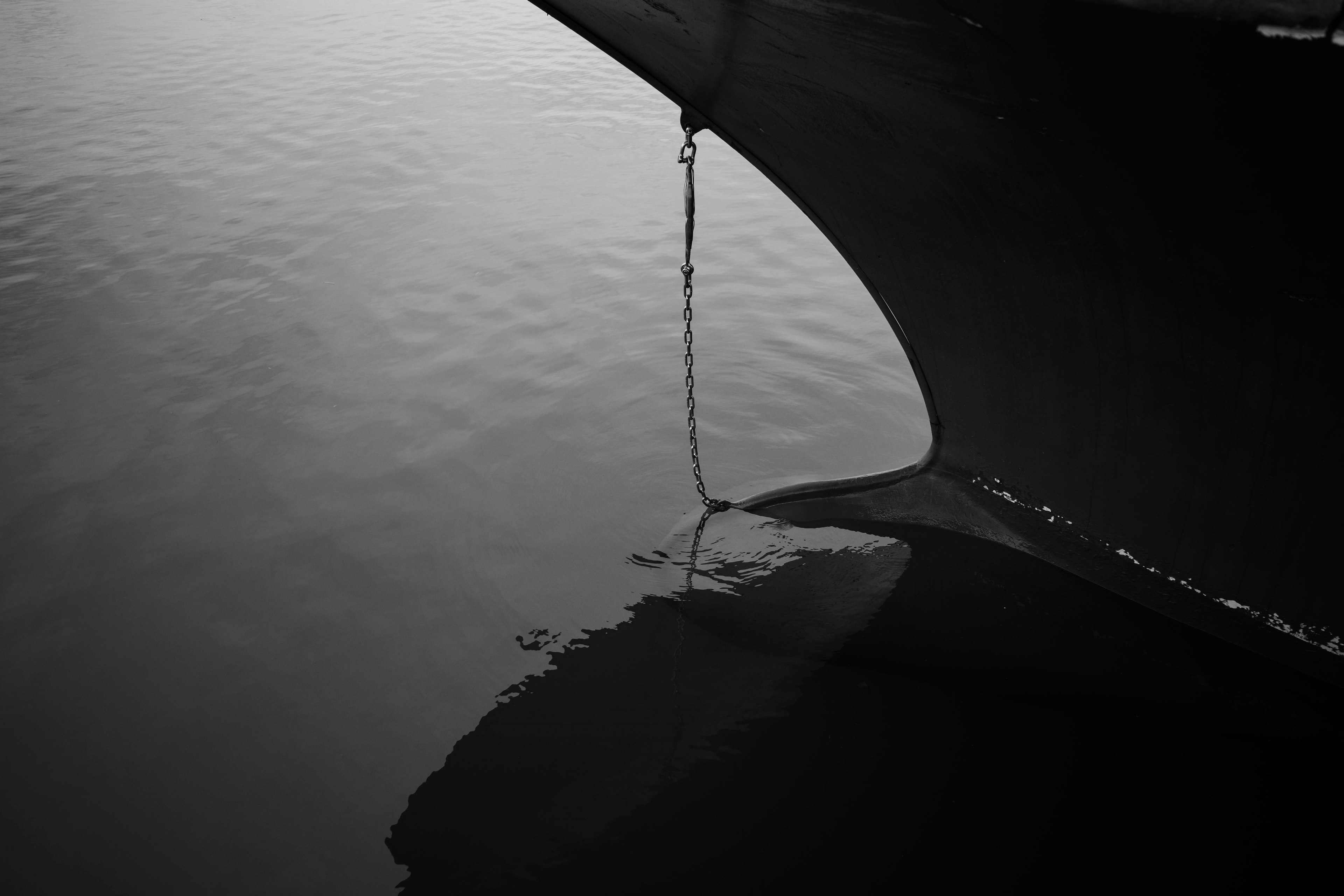 Monochrome Bild des Bugs eines Bootes, das sich auf der Wasseroberfläche spiegelt