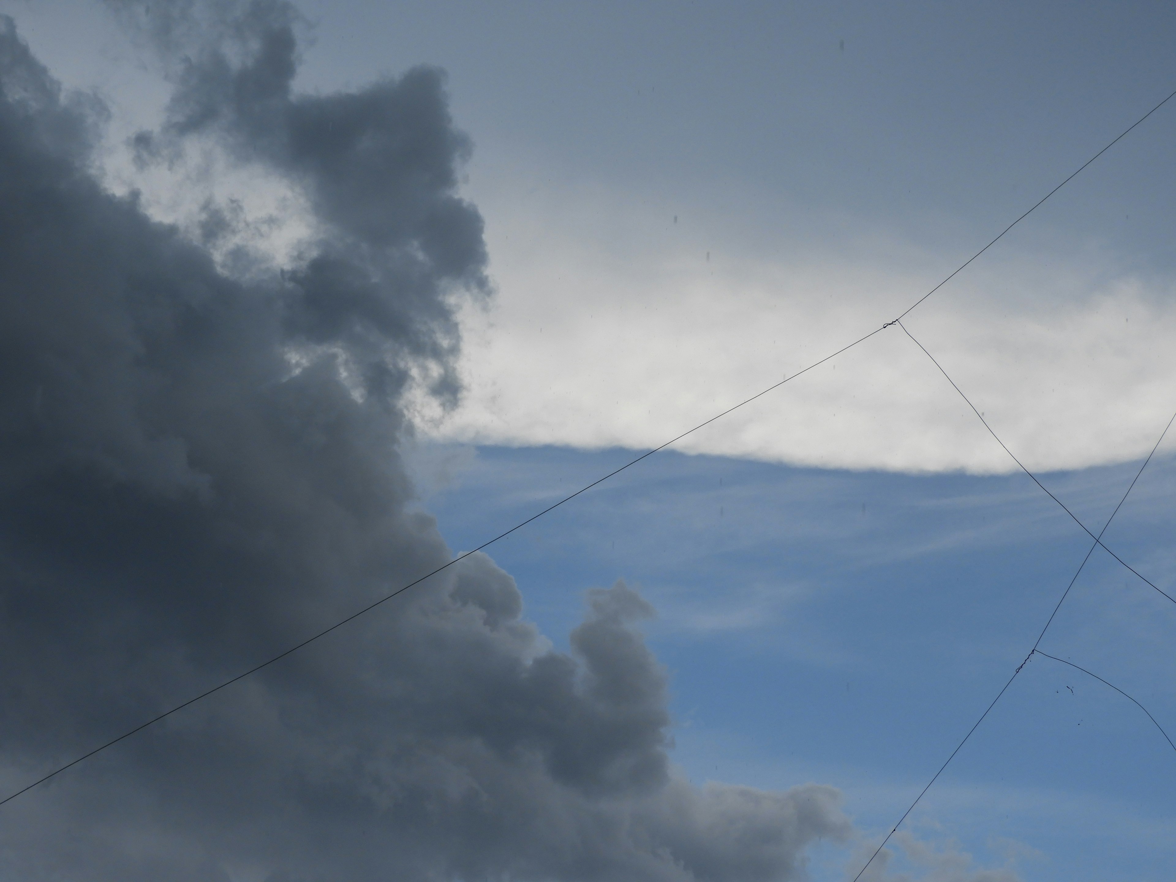 Contraste dramático entre nubes oscuras y cielo azul