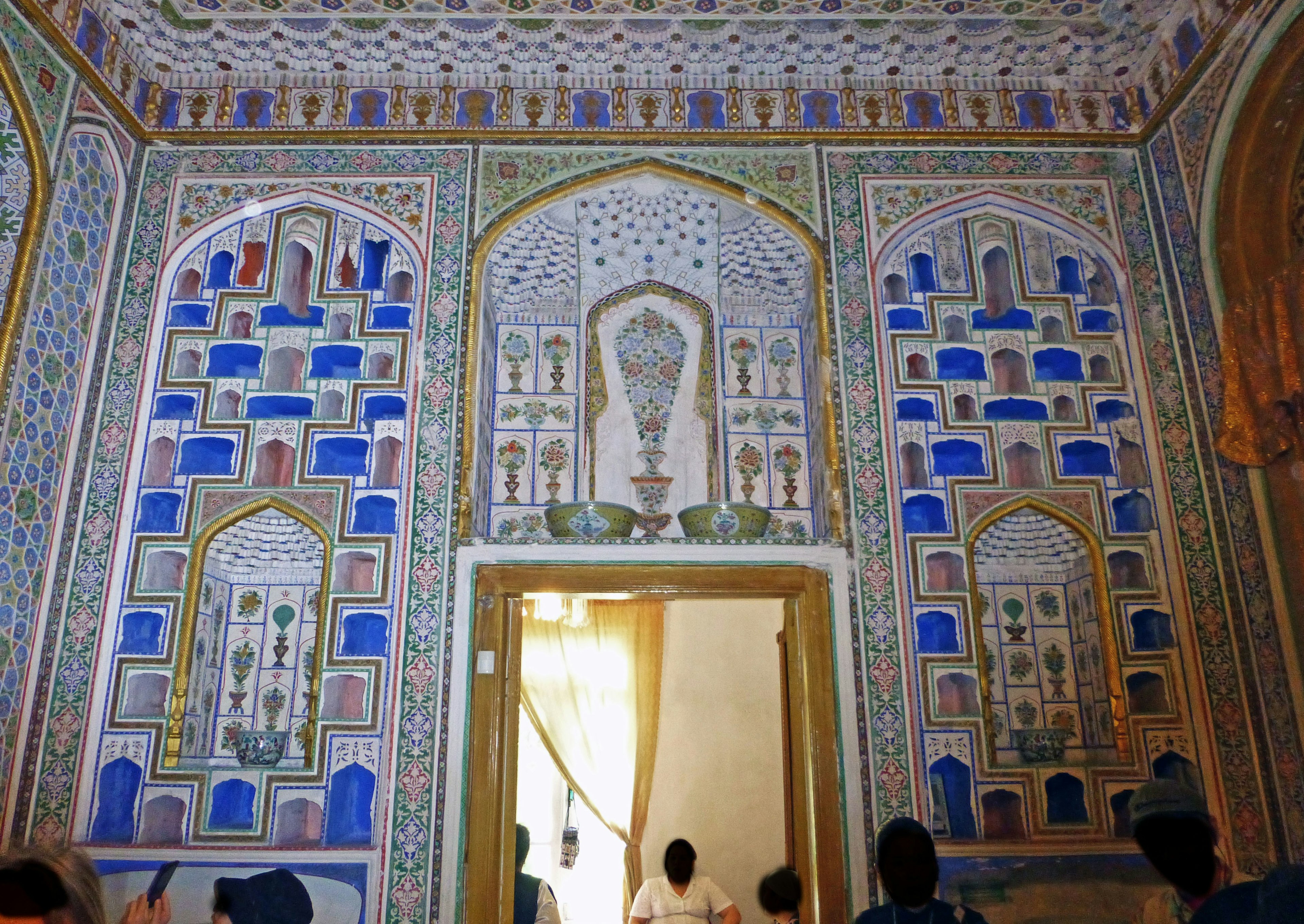 Chambre avec des murs magnifiquement décorés présentant des arches et des motifs colorés