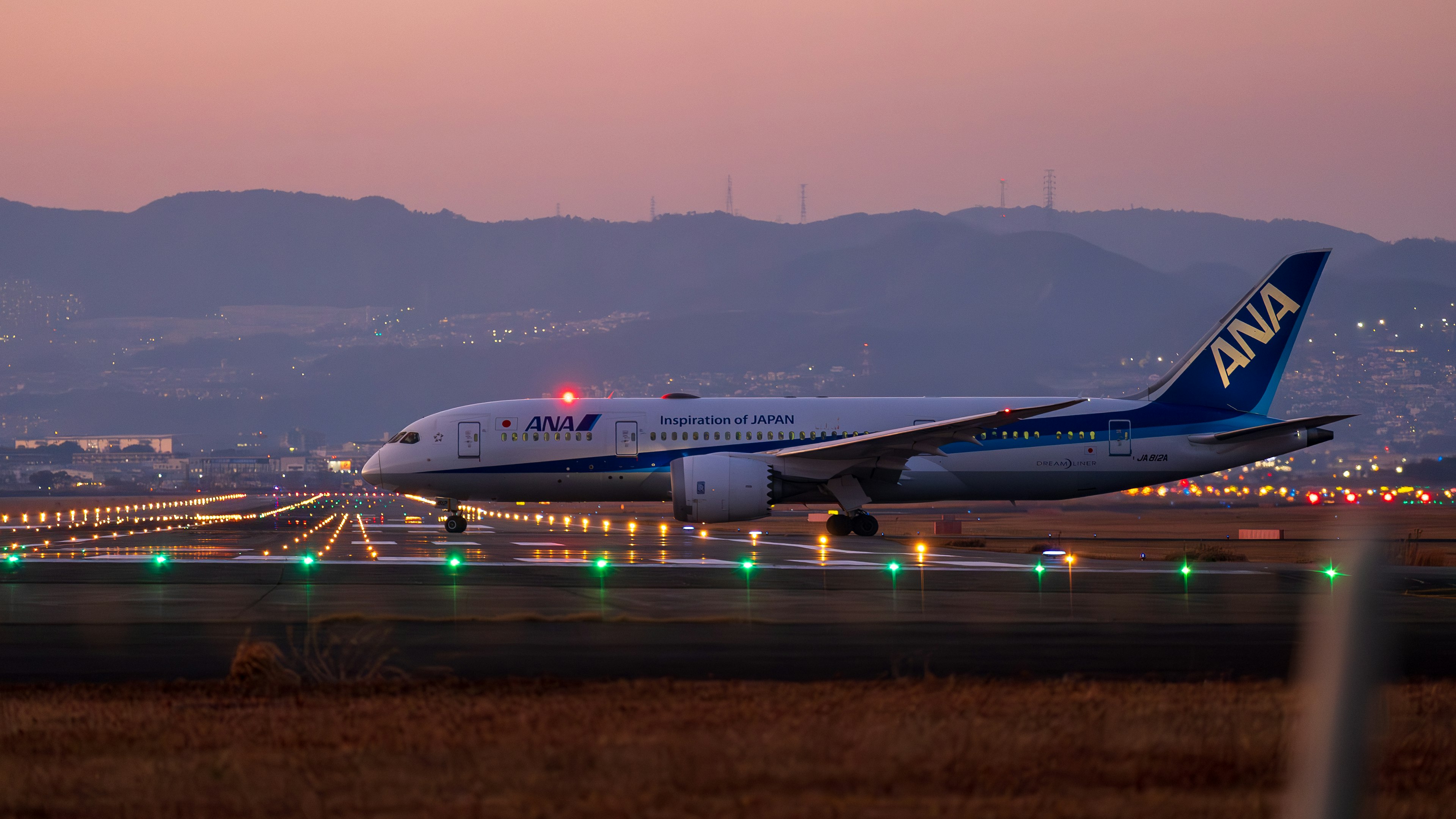 ANAの旅客機が滑走路を走行する夕暮れの風景