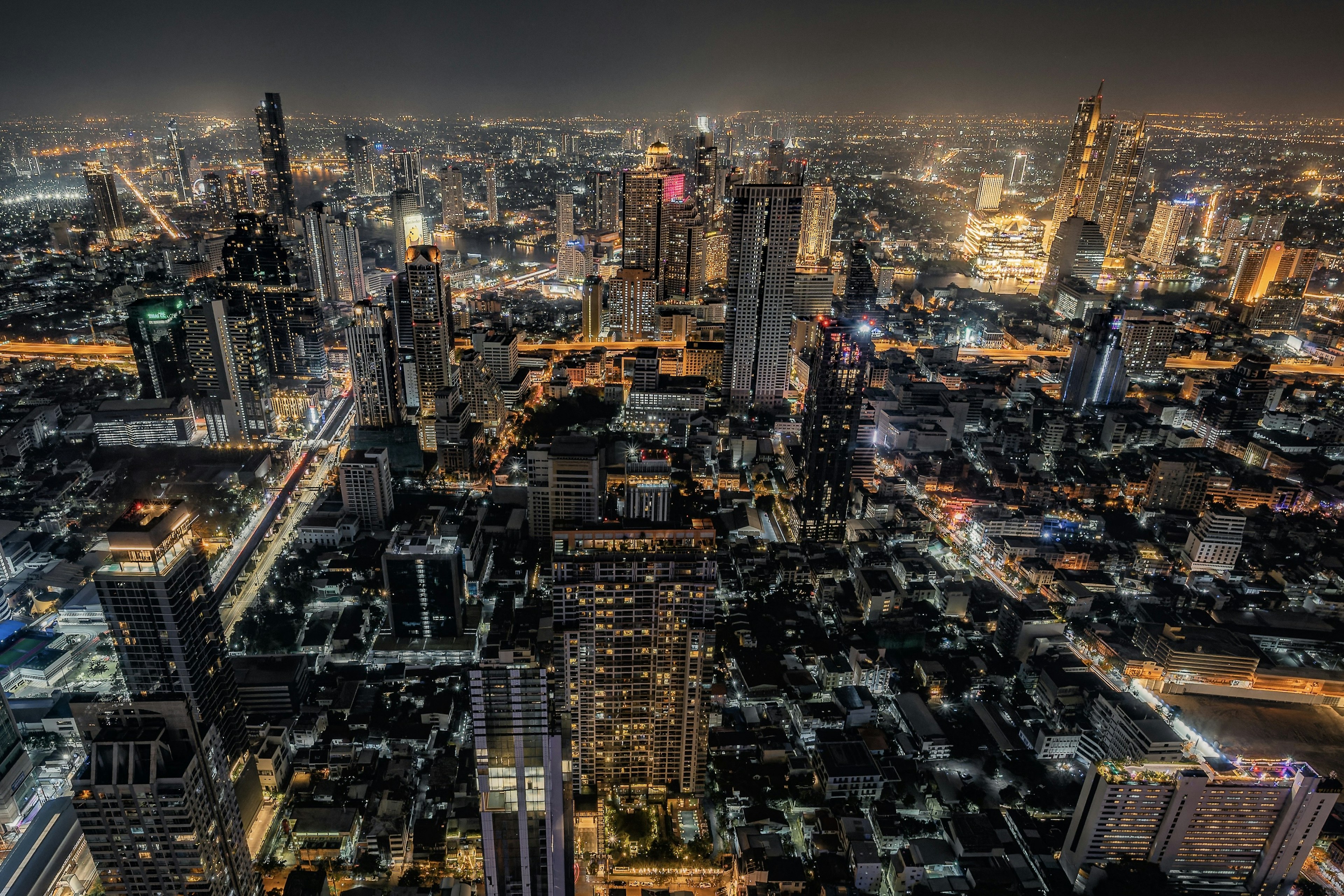 Paysage urbain nocturne avec des gratte-ciel illuminés et des lumières vives