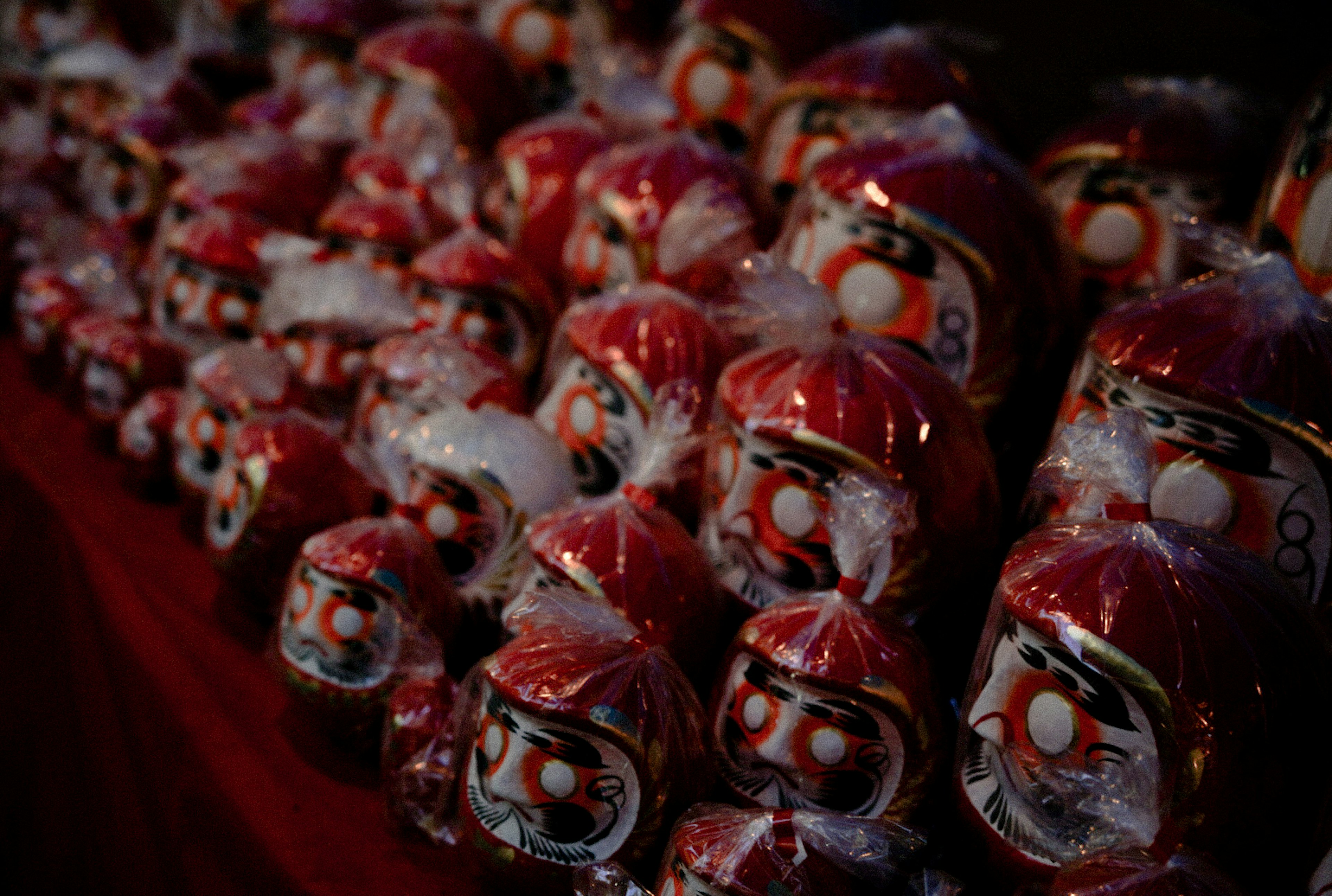 Une exposition de poupées Daruma rouges disposées en rangées