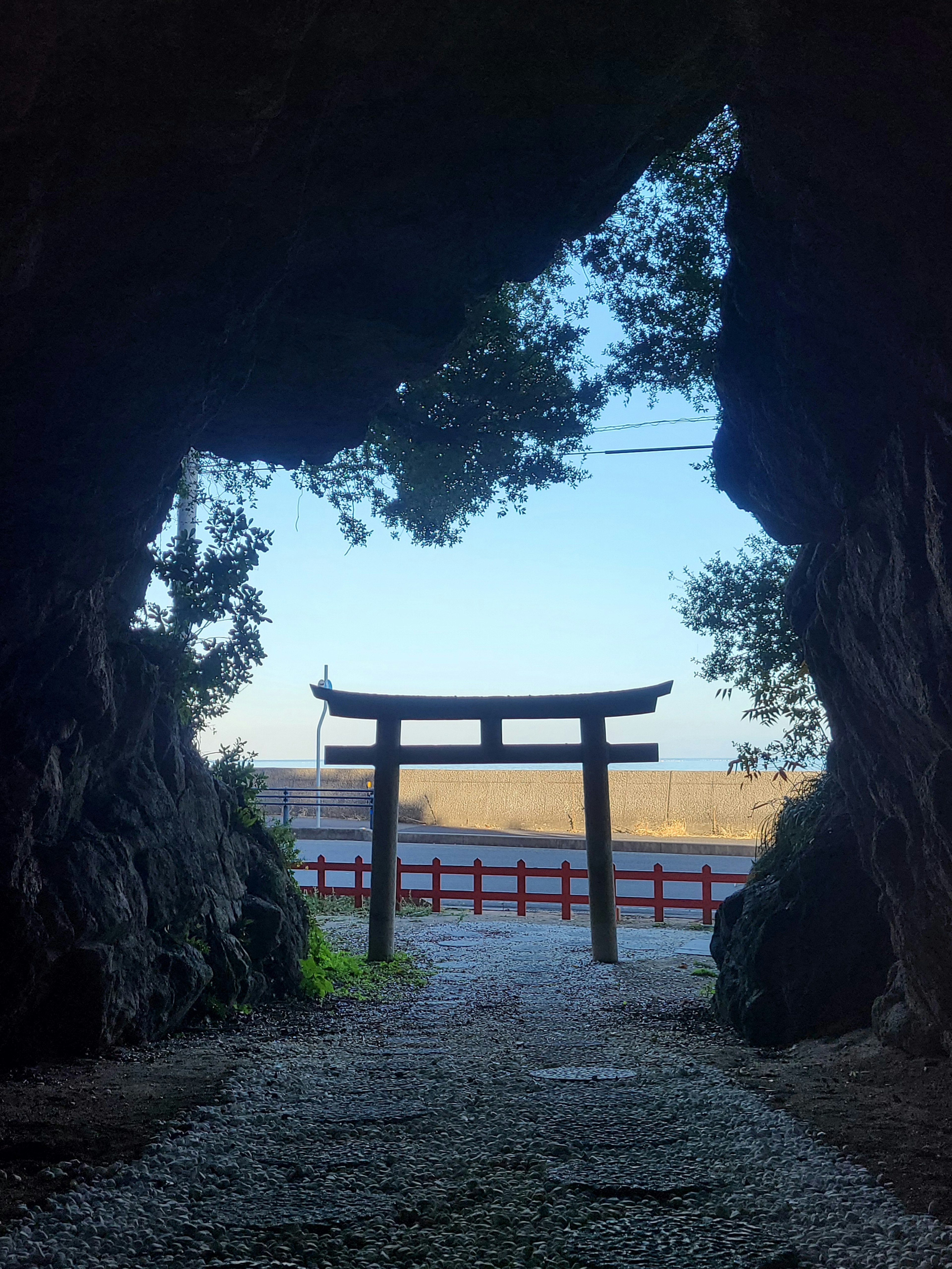 Blick auf ein Torii, eingerahmt von einem Höhleneingang