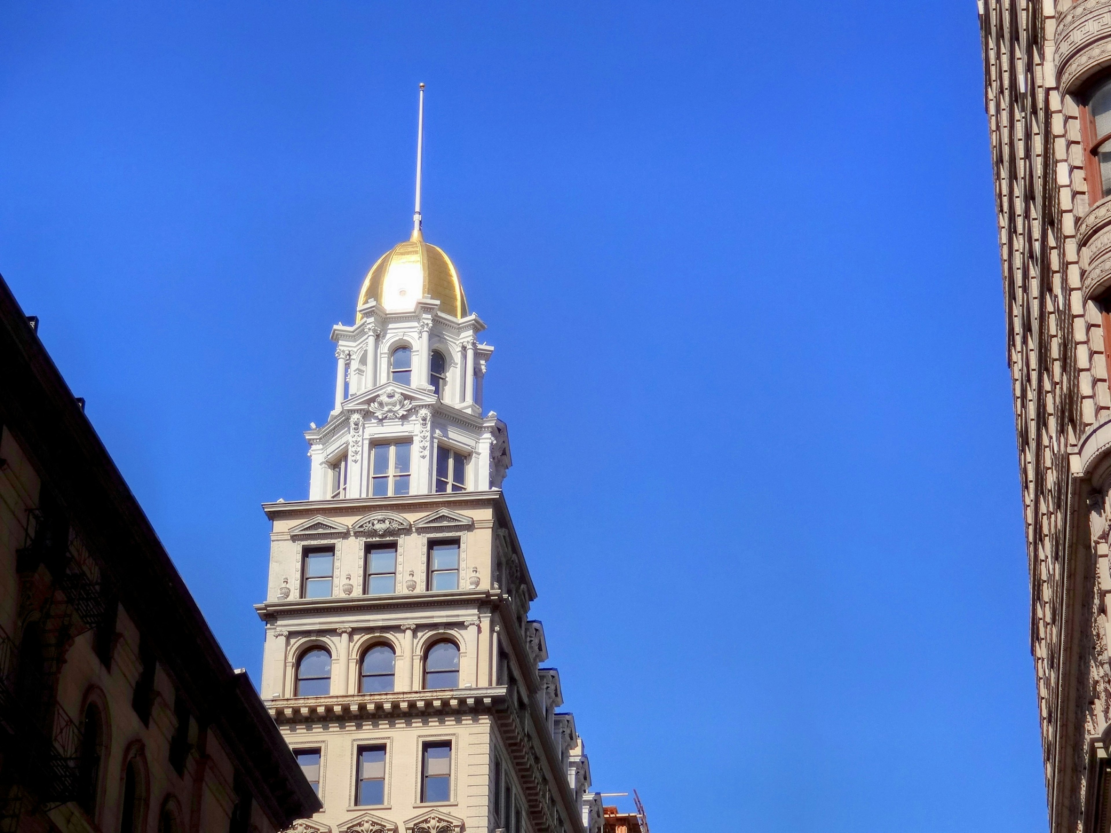 Historic building with a golden dome towering against a blue sky