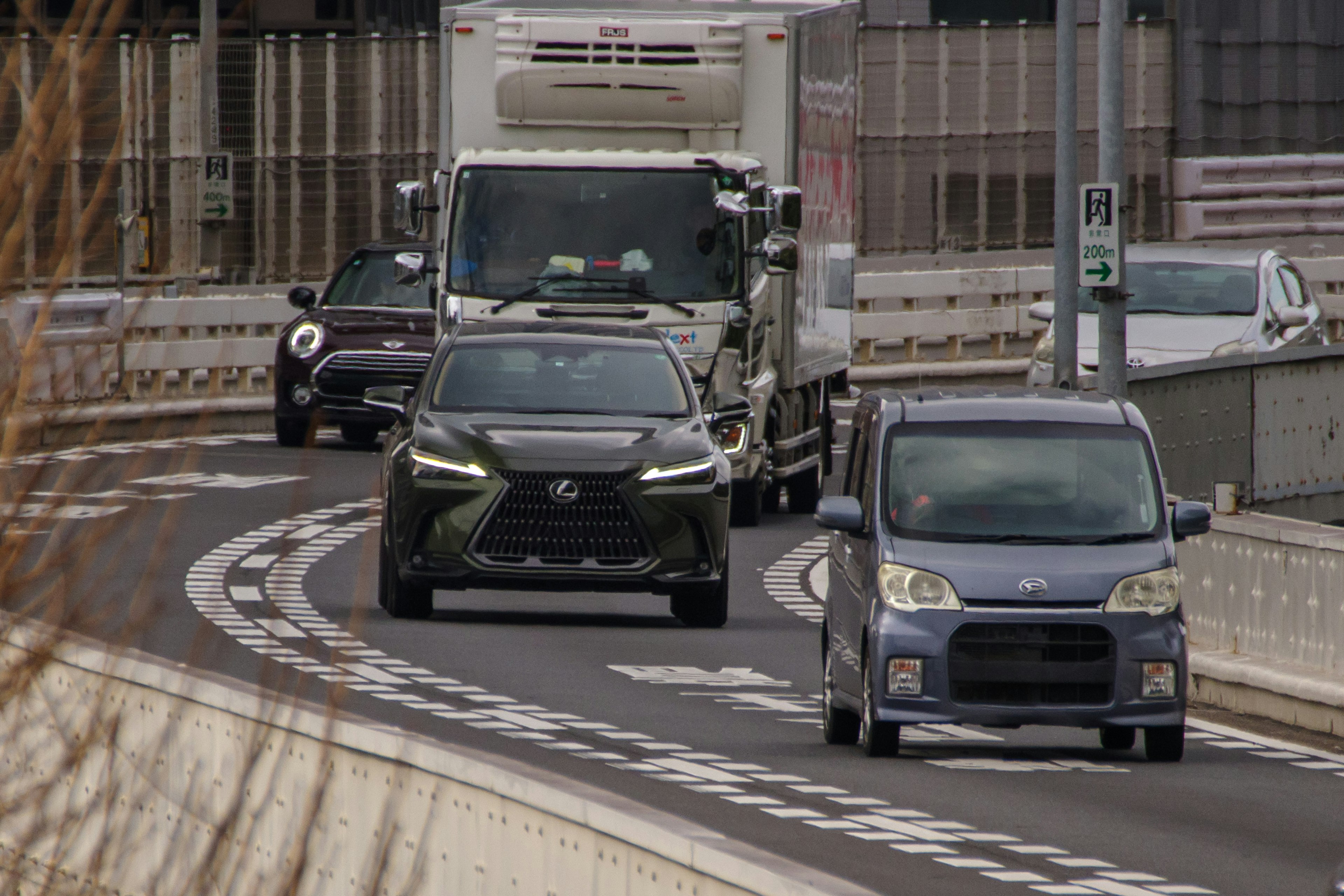 都市の道路を走る複数の車両とトラック