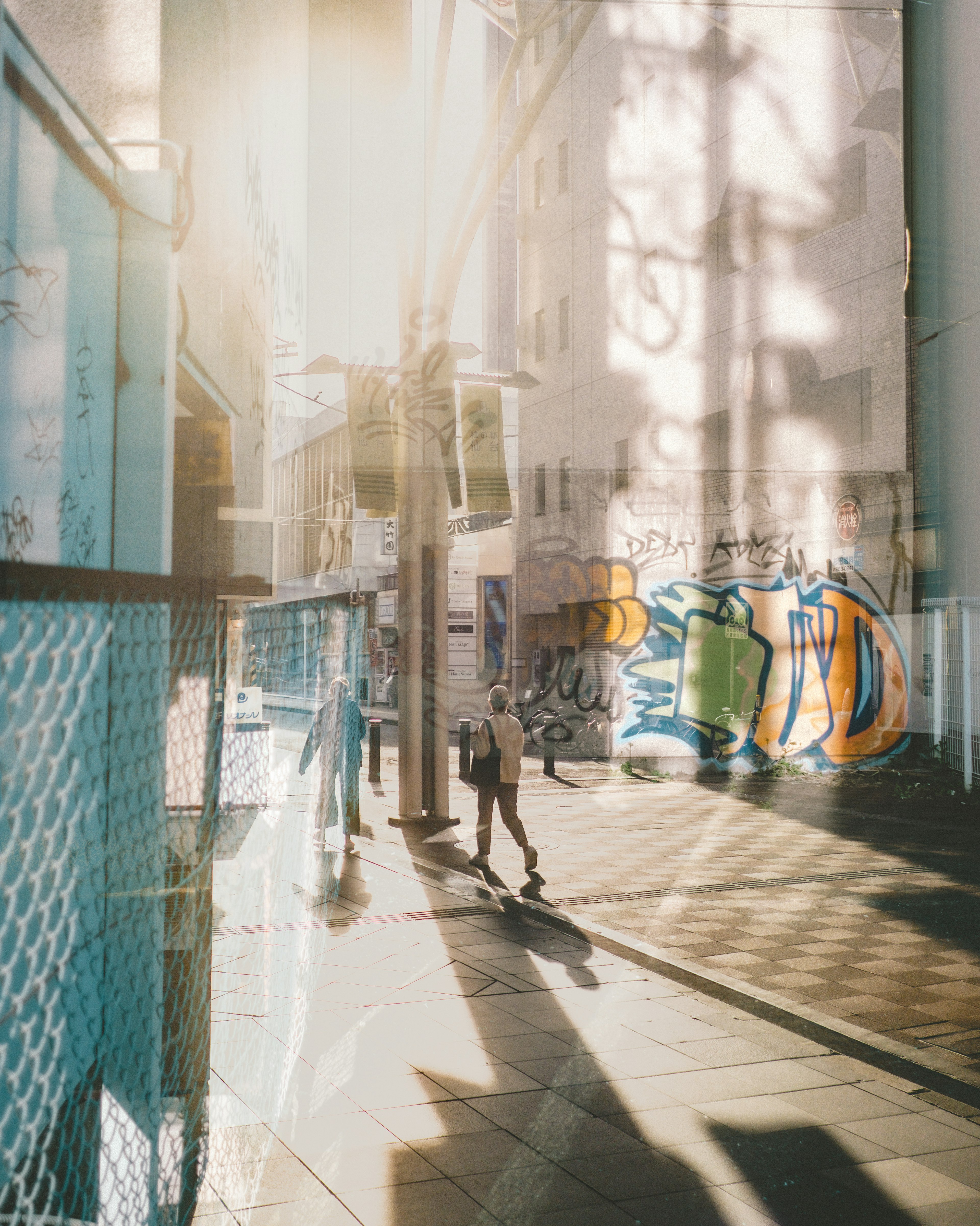 Colorful street corner with graffiti people walking in the sunlight shadows