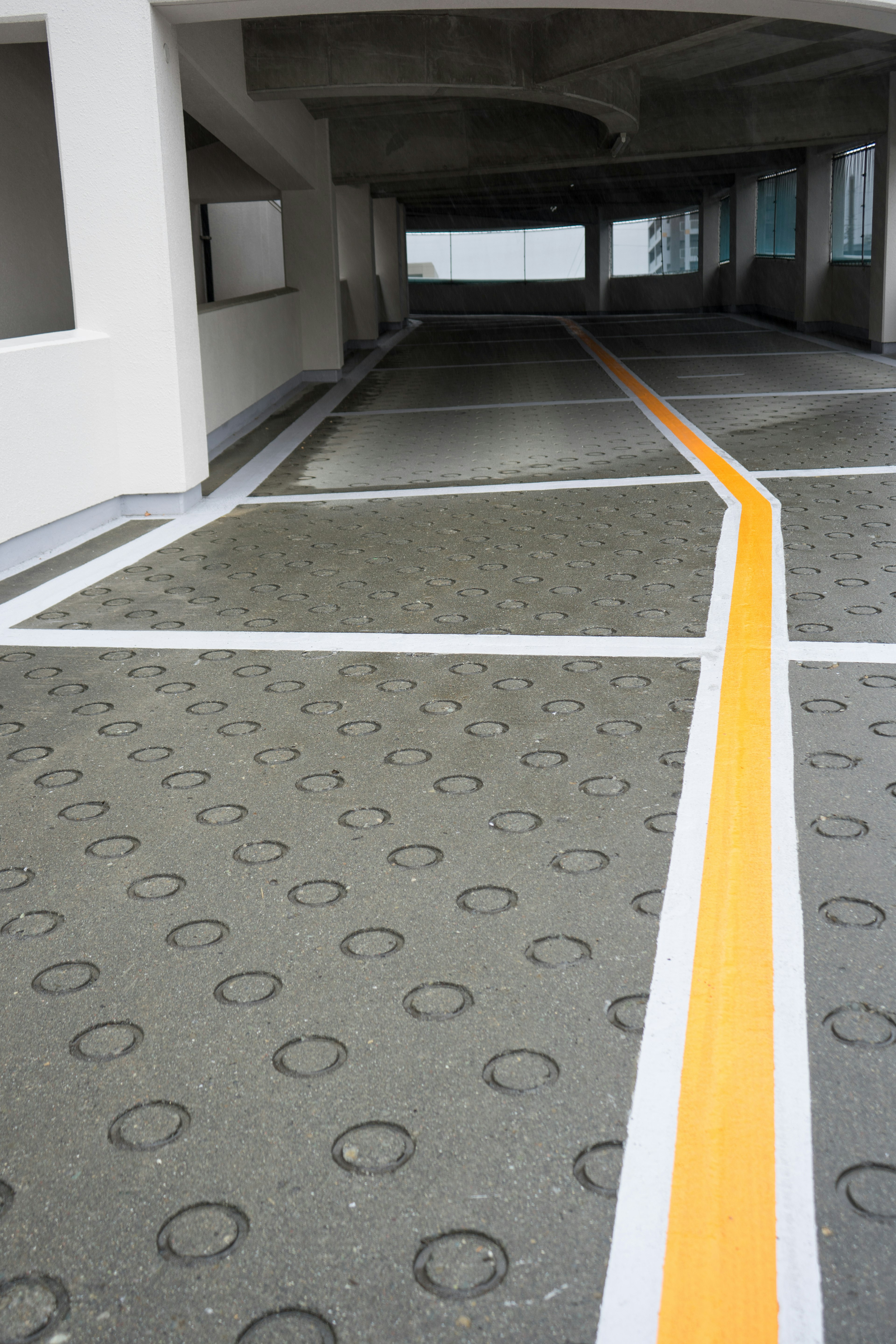 Parking lot floor with yellow and white lines and circular patterns