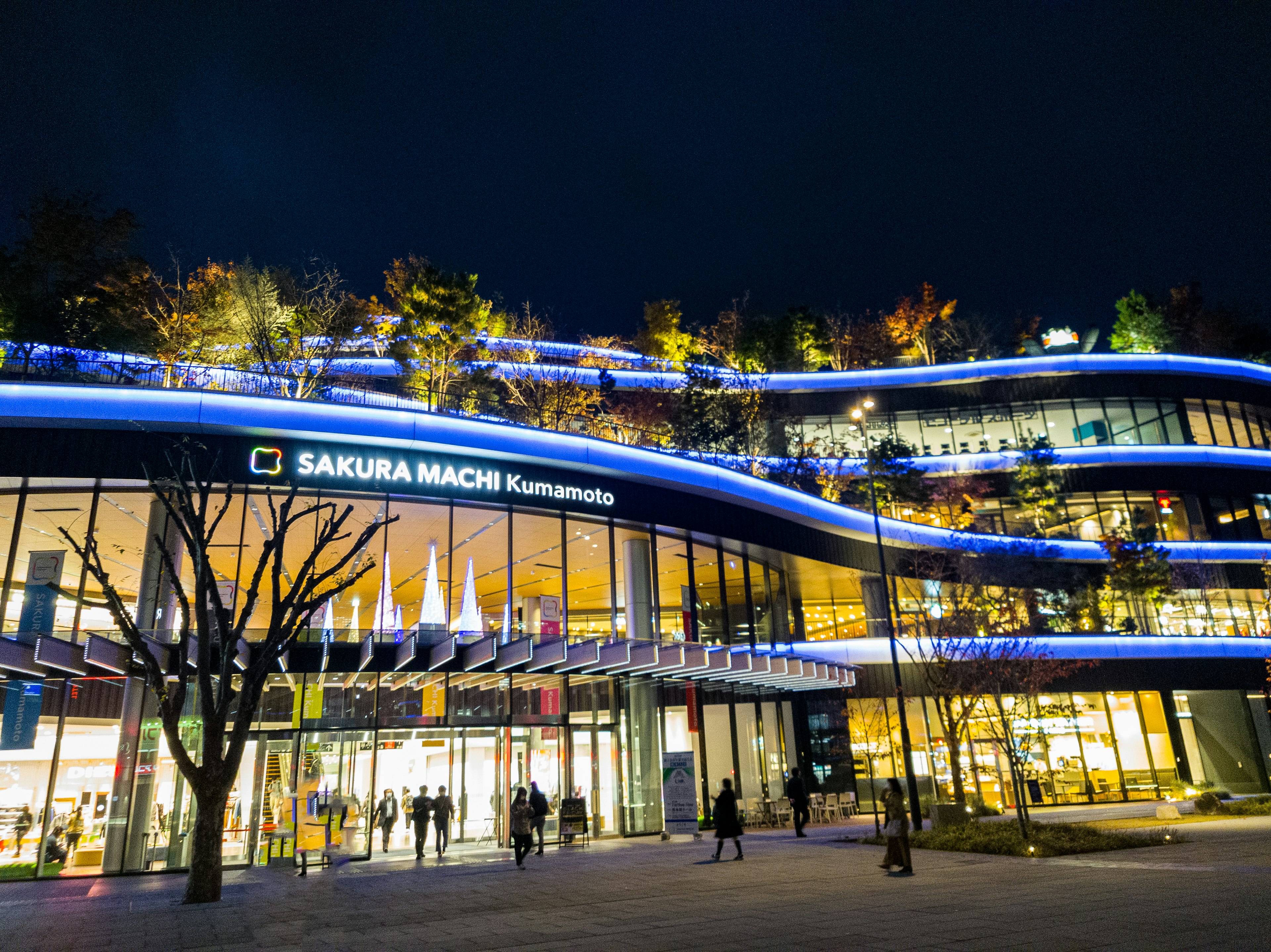 Modernes Gebäude von Sakura Machi, das nachts von blauen Lichtern beleuchtet wird