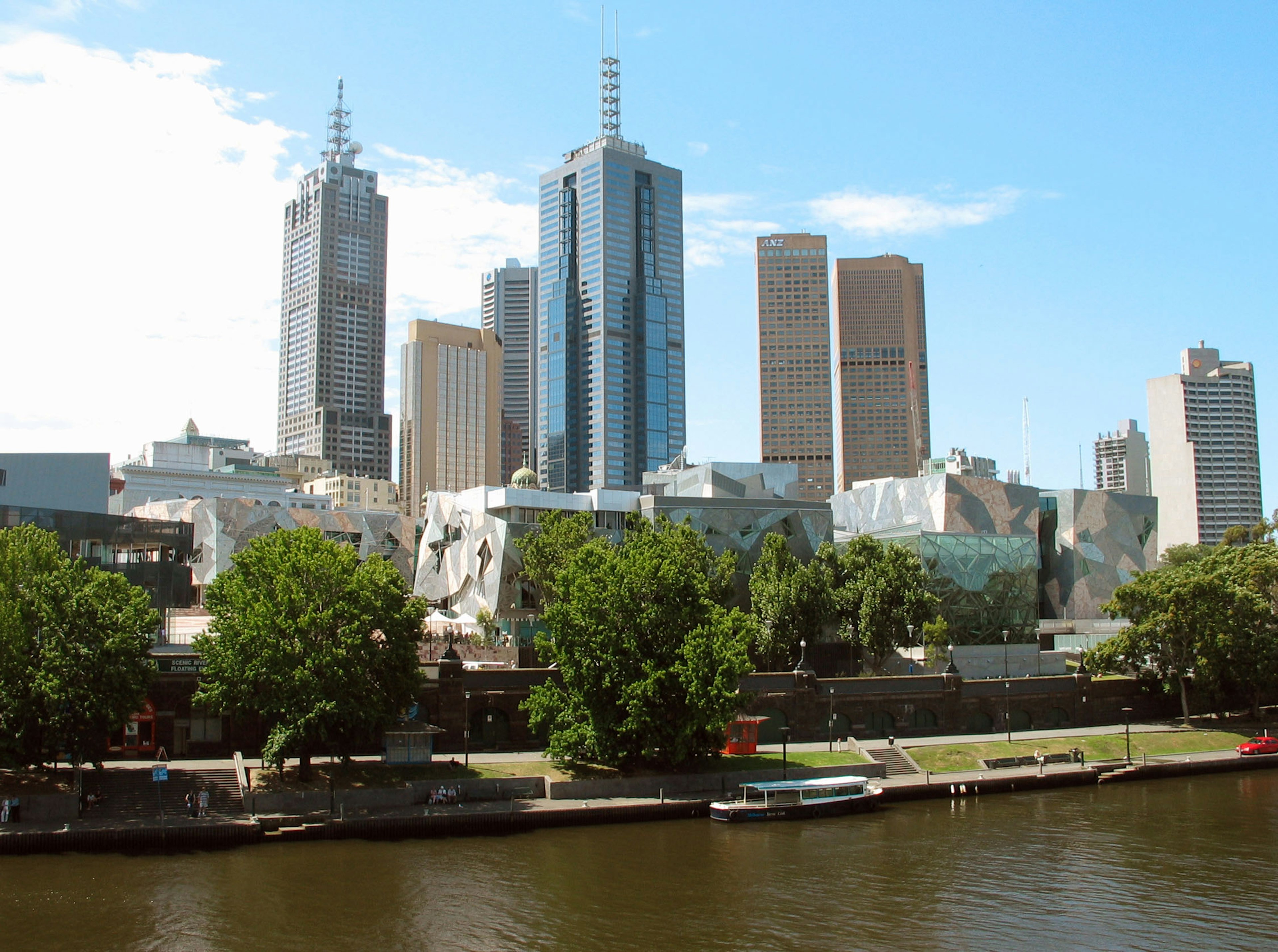 Garis langit Melbourne dengan gedung pencakar langit modern dan pemandangan Sungai Yarra di bawah langit biru cerah