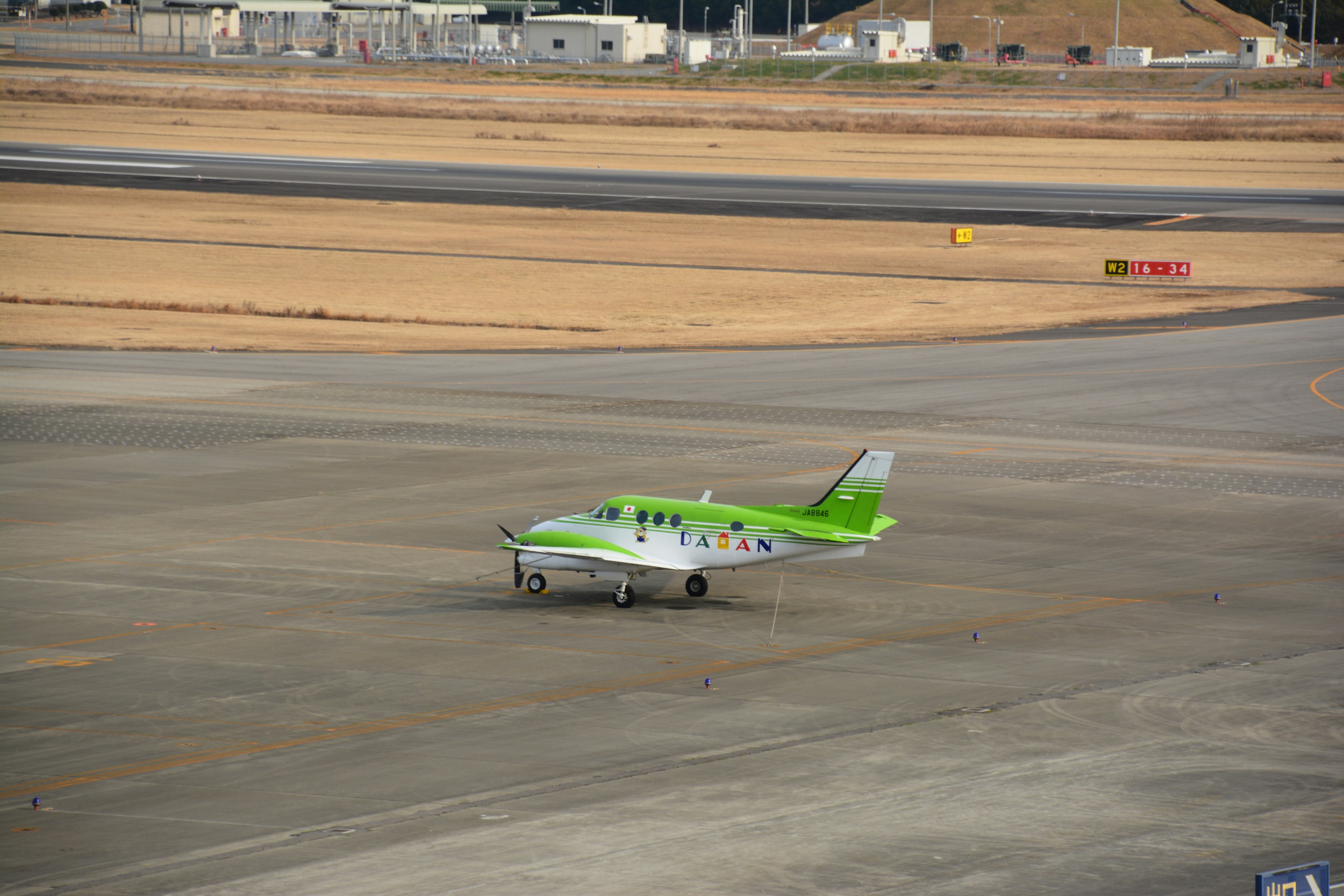 Una pequeña aeronave verde estacionada en una pista de aeropuerto