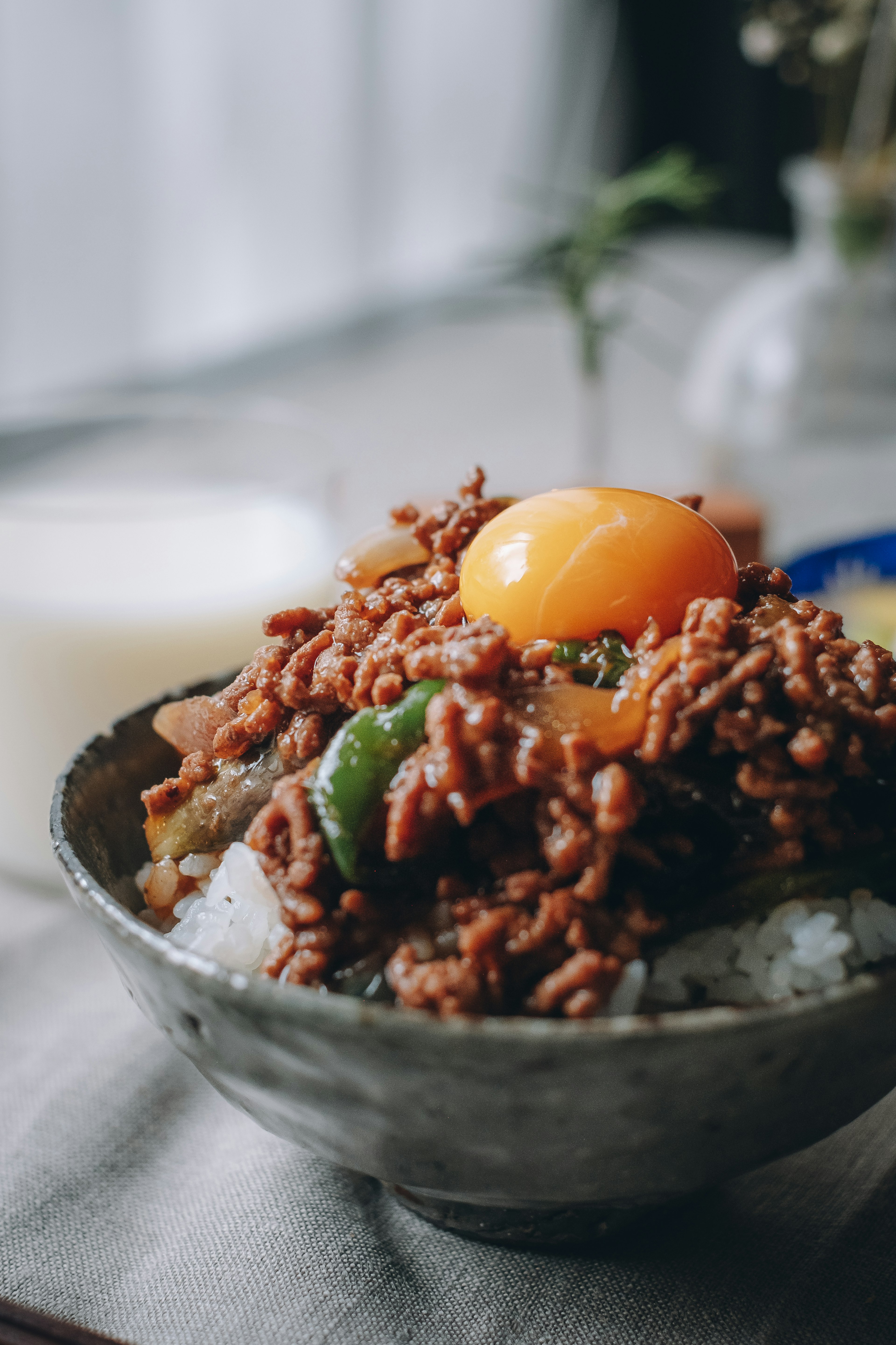 Bowl of rice topped with raw egg and minced meat