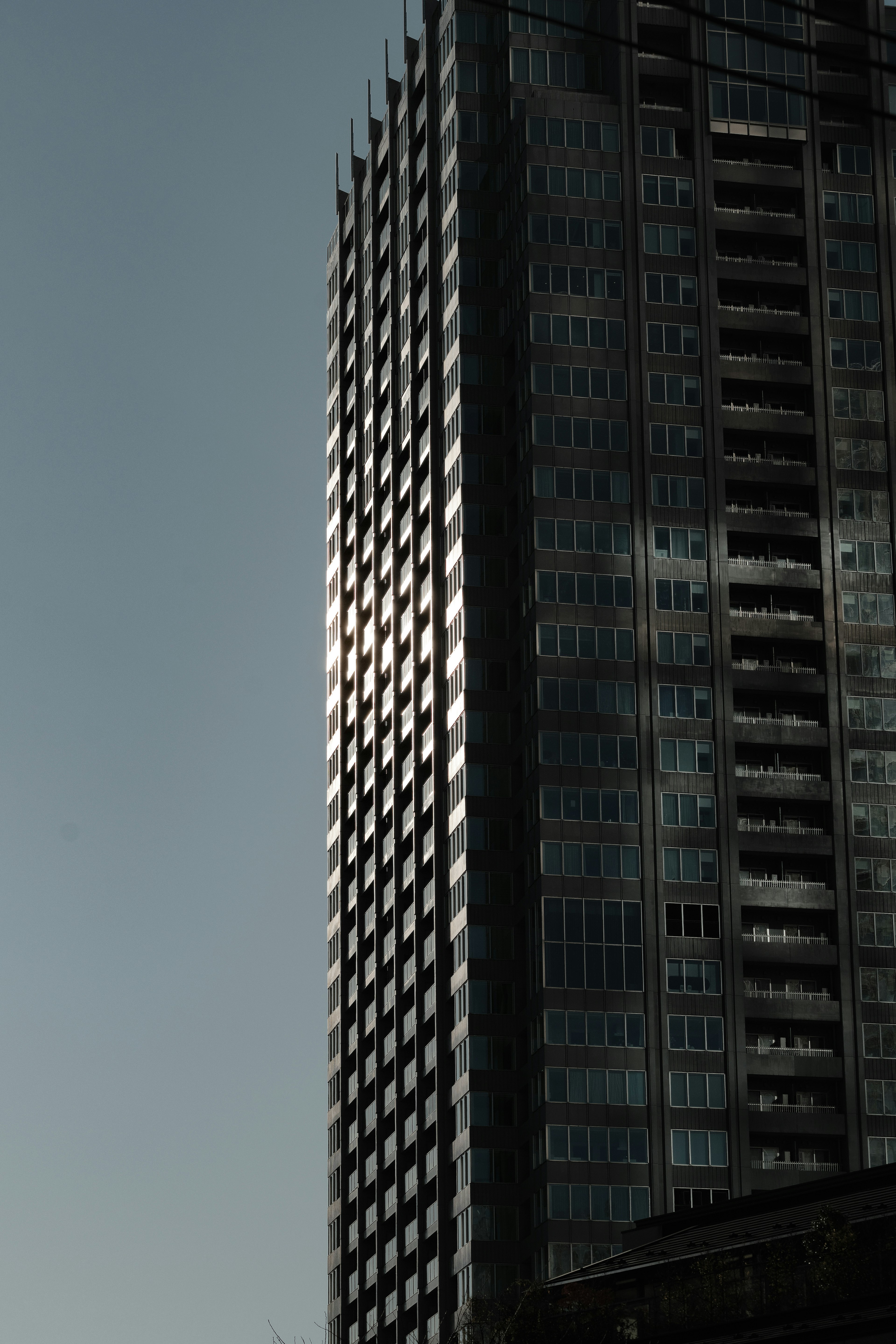 Gratte-ciel moderne réfléchissant la lumière du soleil avec une façade lisse