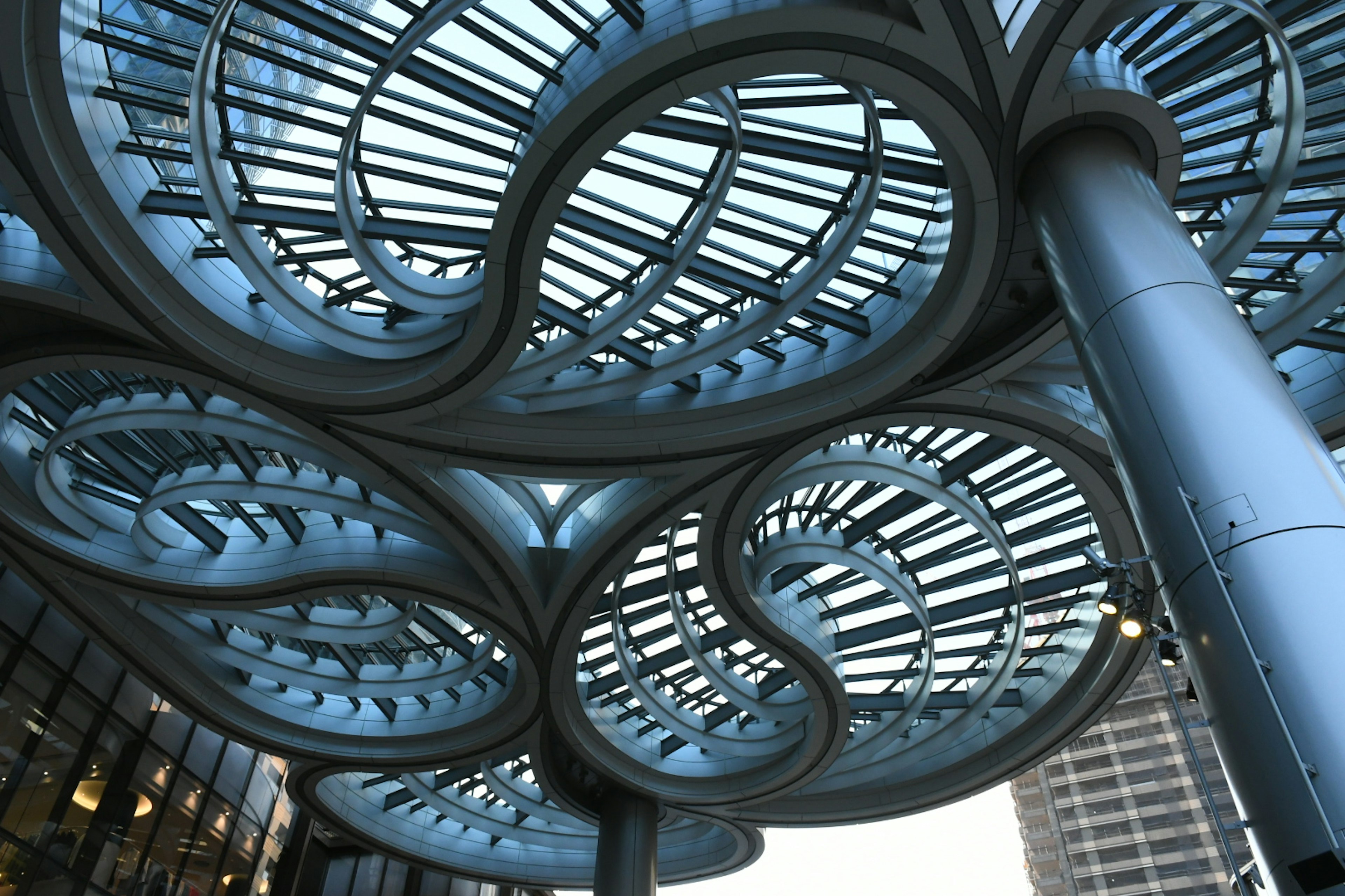 View from below a modern architectural design featuring wave-like roof structure