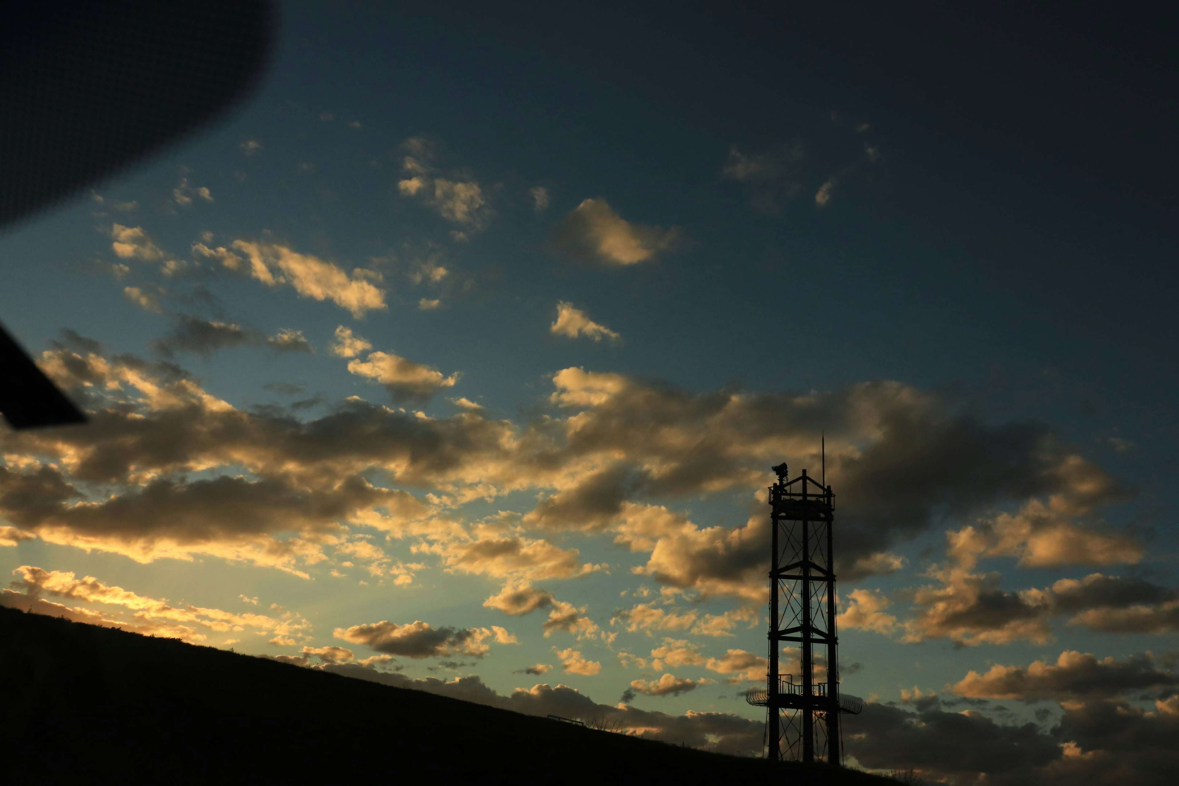 夕焼けの空とシルエットの塔が映る風景