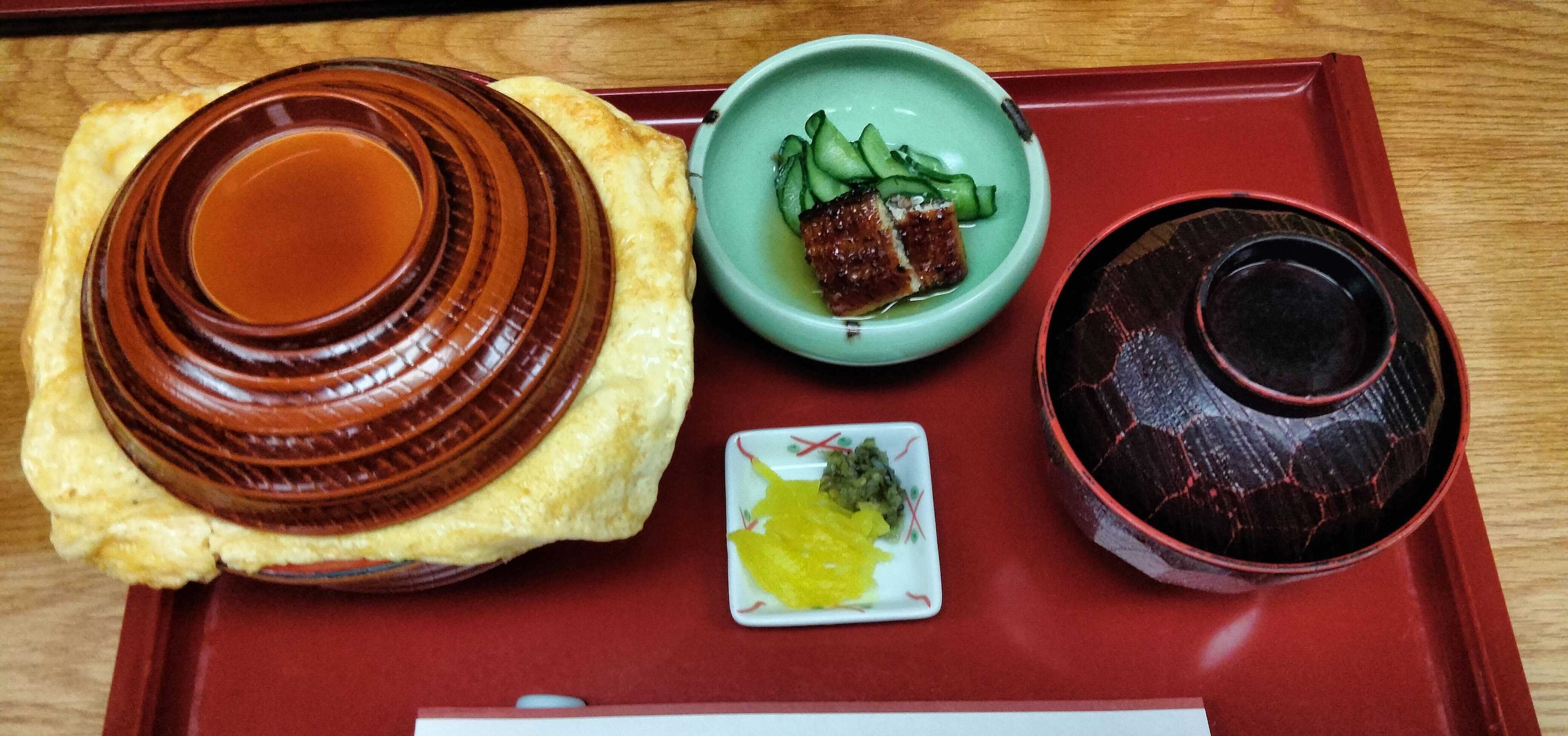 Eine schön angerichtete japanische Mahlzeit mit einer Holzschüssel und kleinen Beilagen