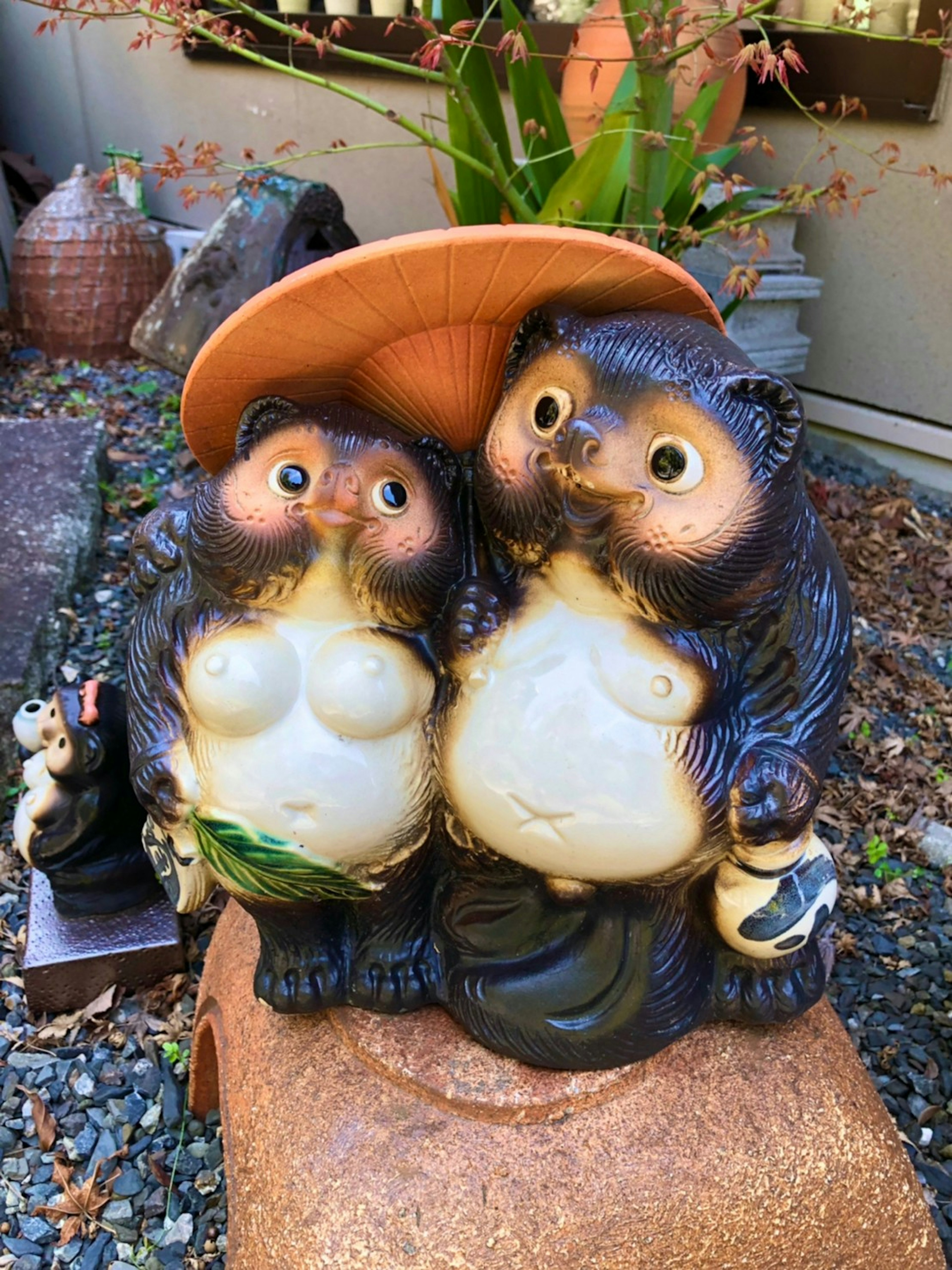 Deux figurines de tanuki se tenant près l'une de l'autre