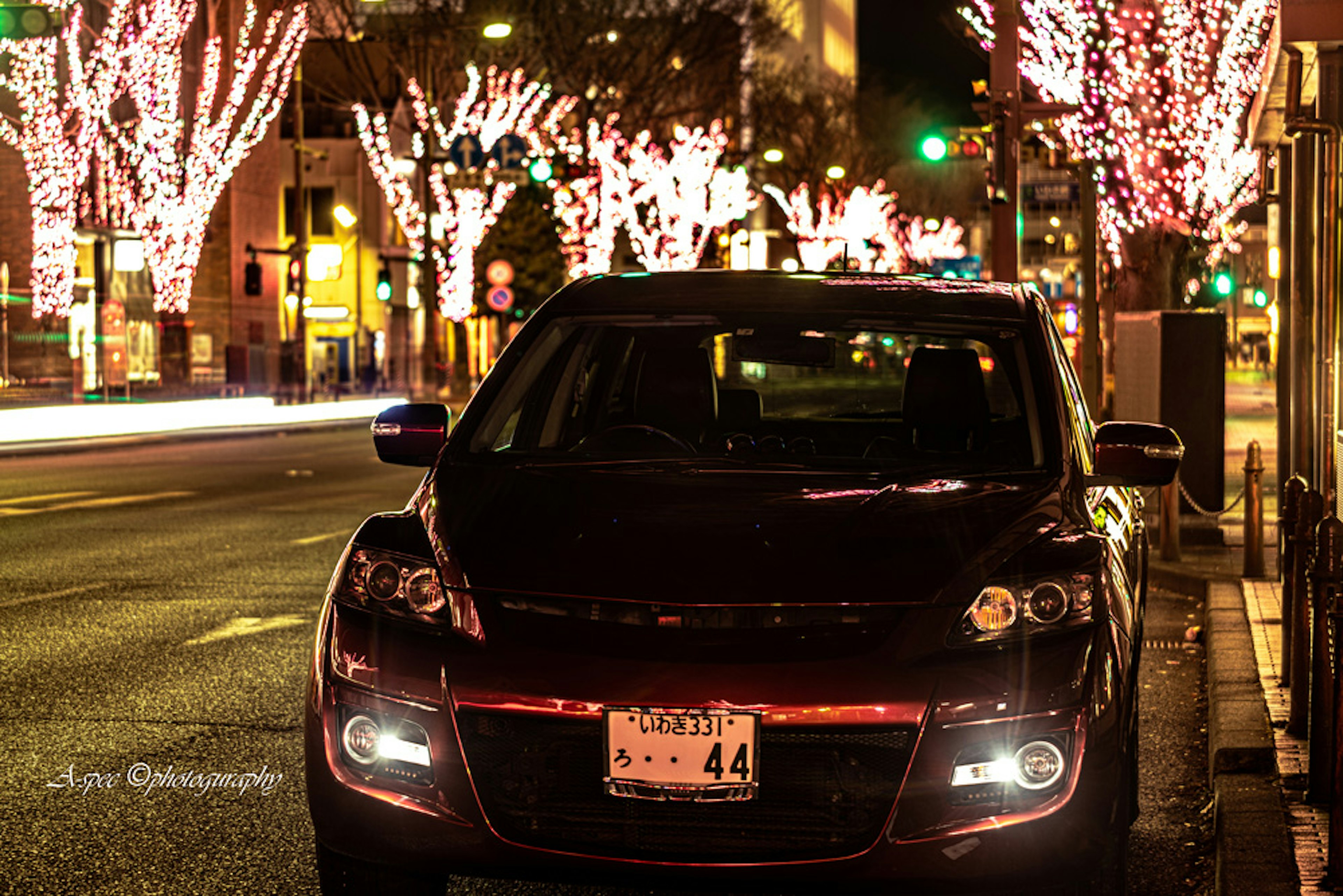 夜の街並みを背景にした黒い車とイルミネーション