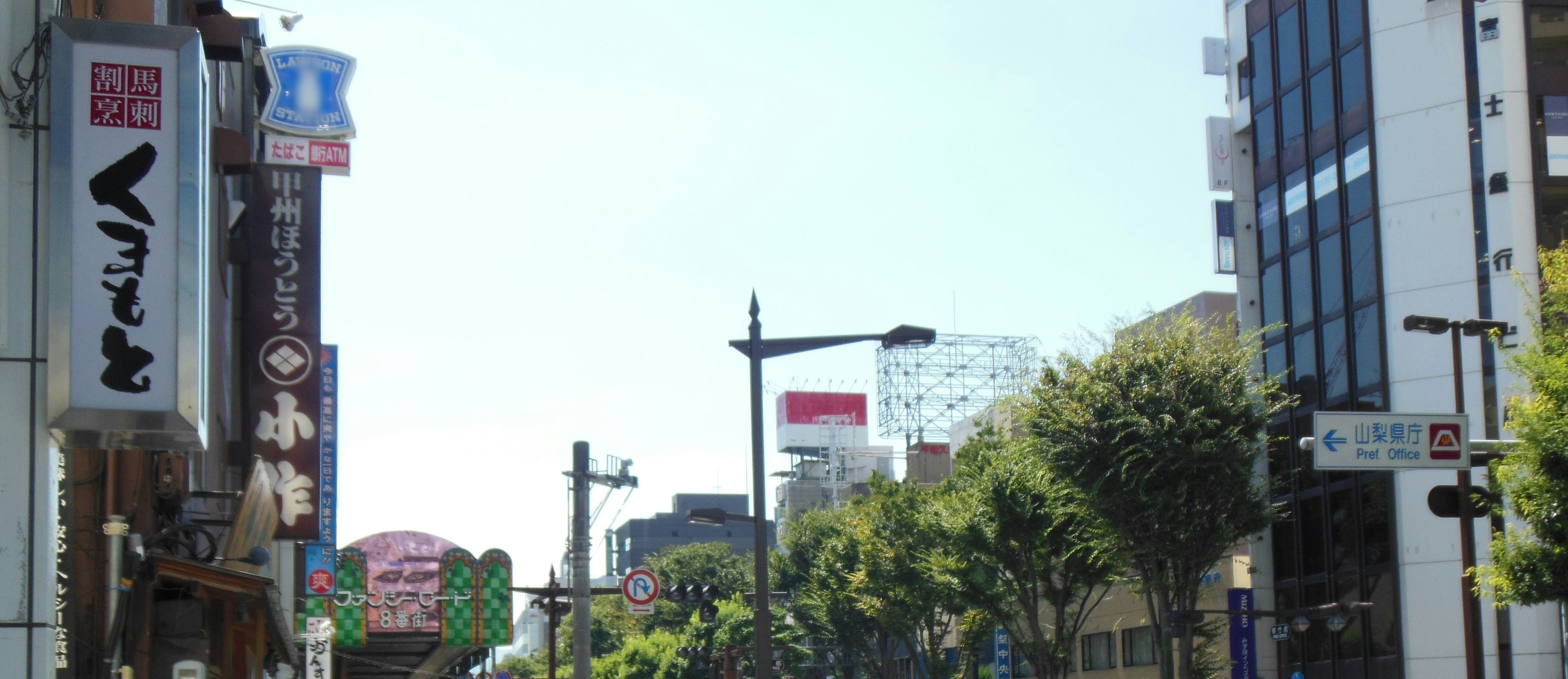 Street view with buildings and blue sky featuring signs and streetlights