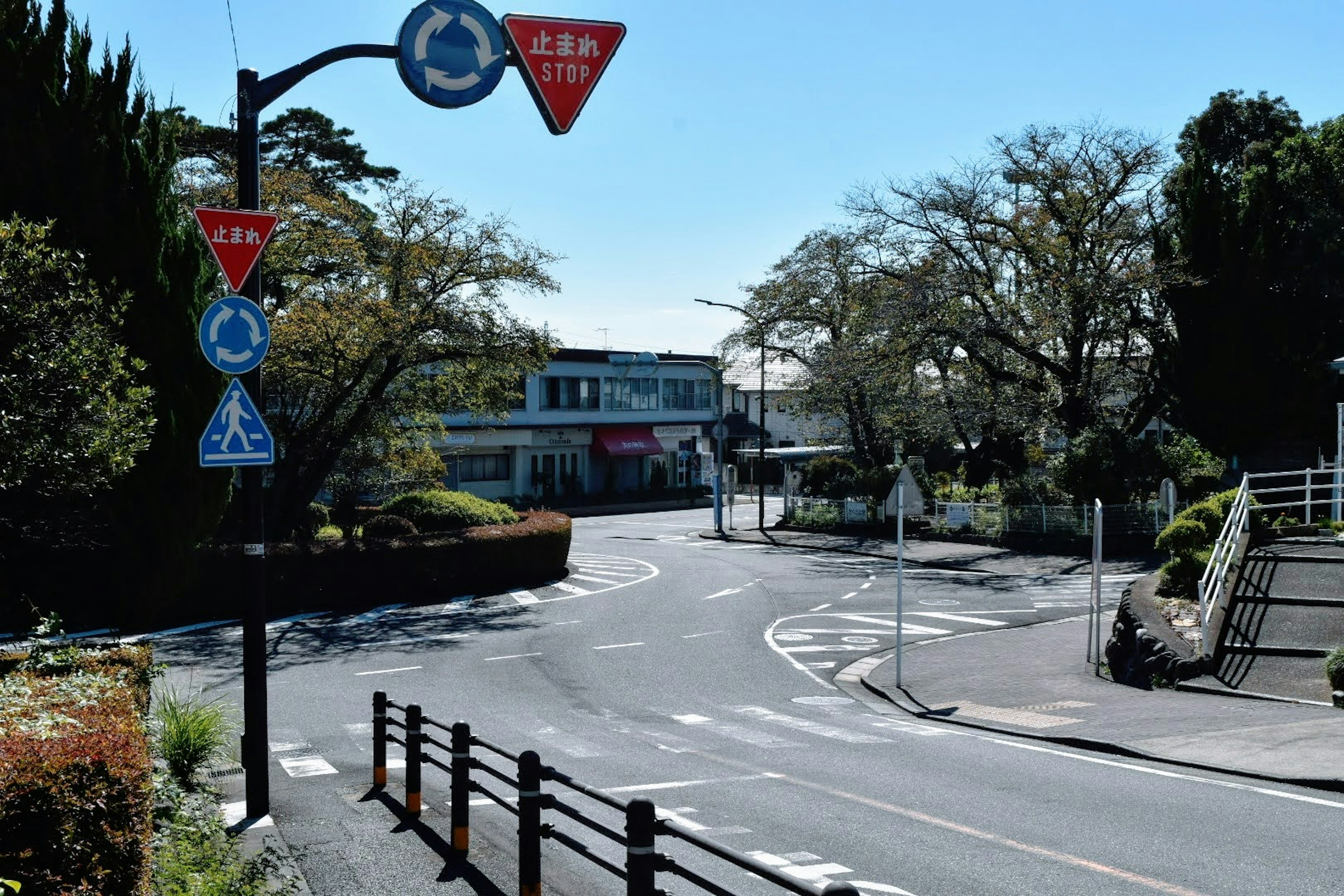 青空の下にあるカーブした道路と交通標識が見える風景