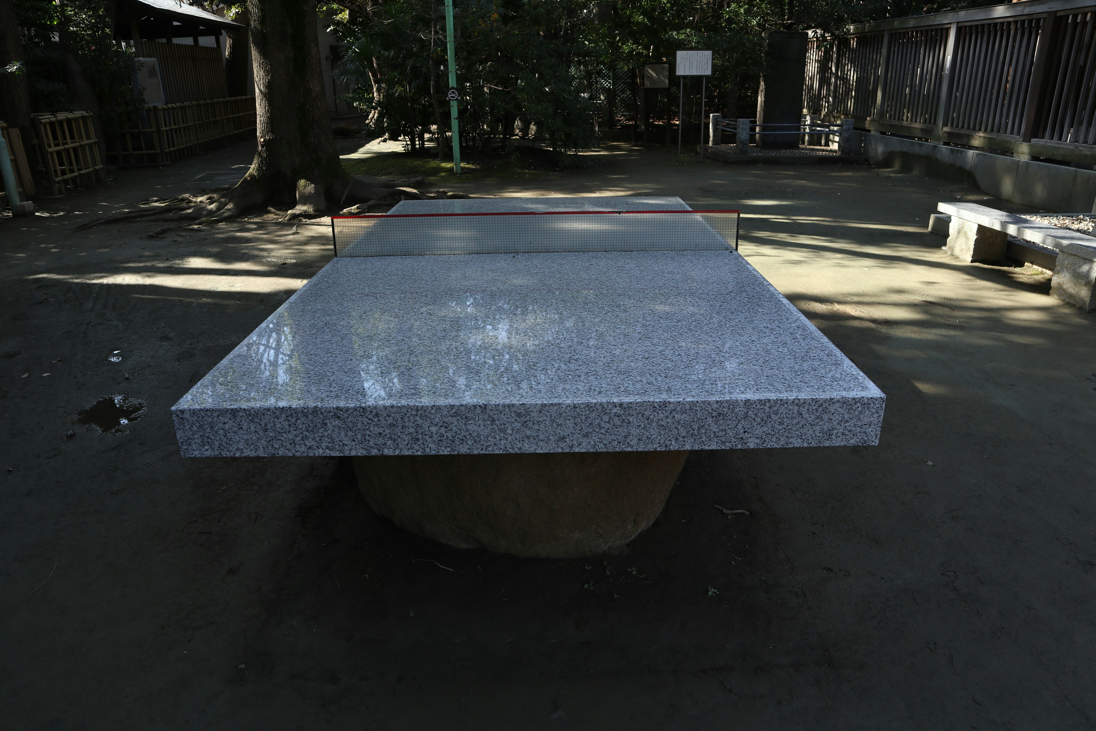 Table en pierre dans un parc avec des bancs environnants