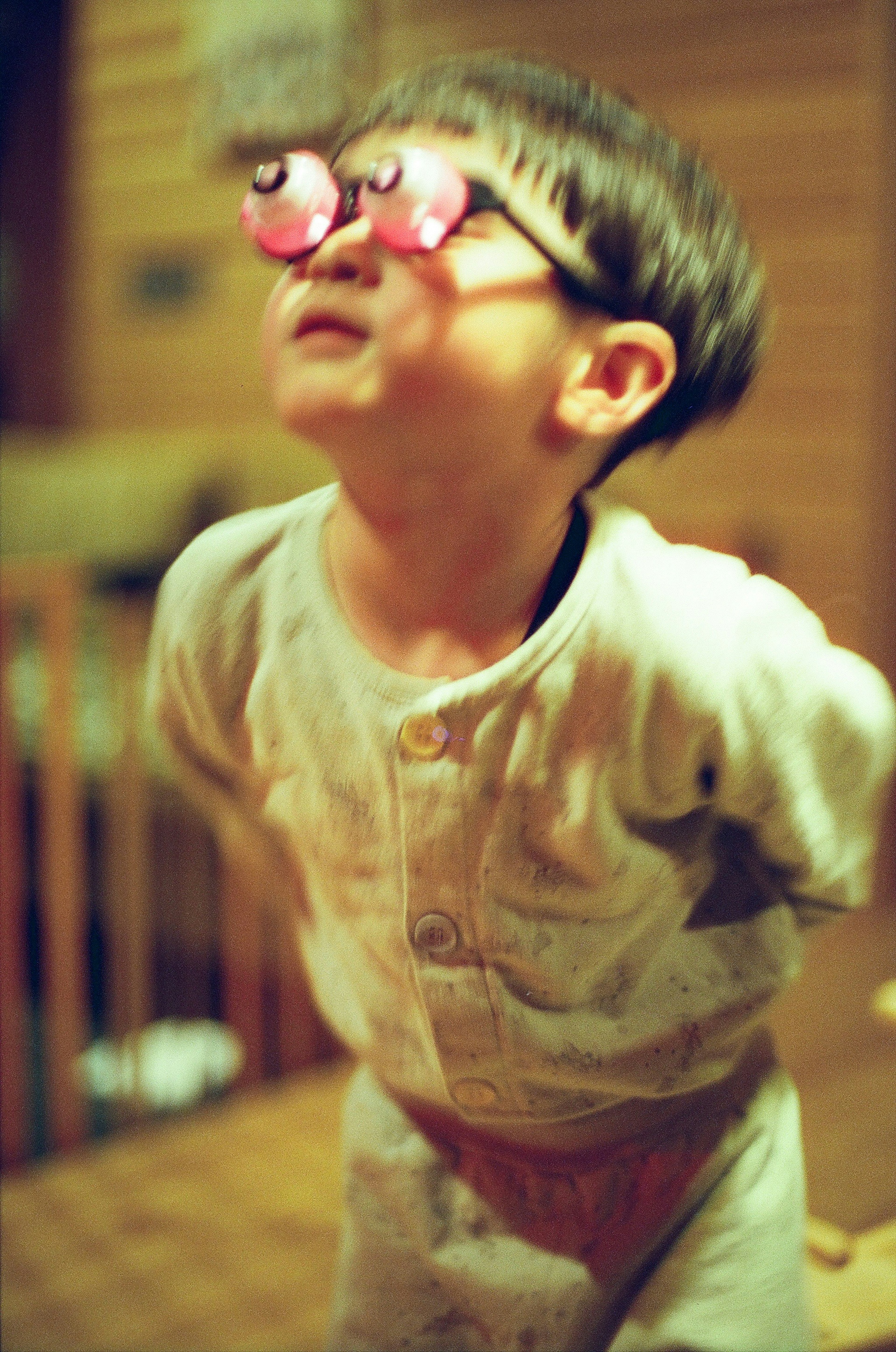 Niño con gafas rosas mirando hacia arriba