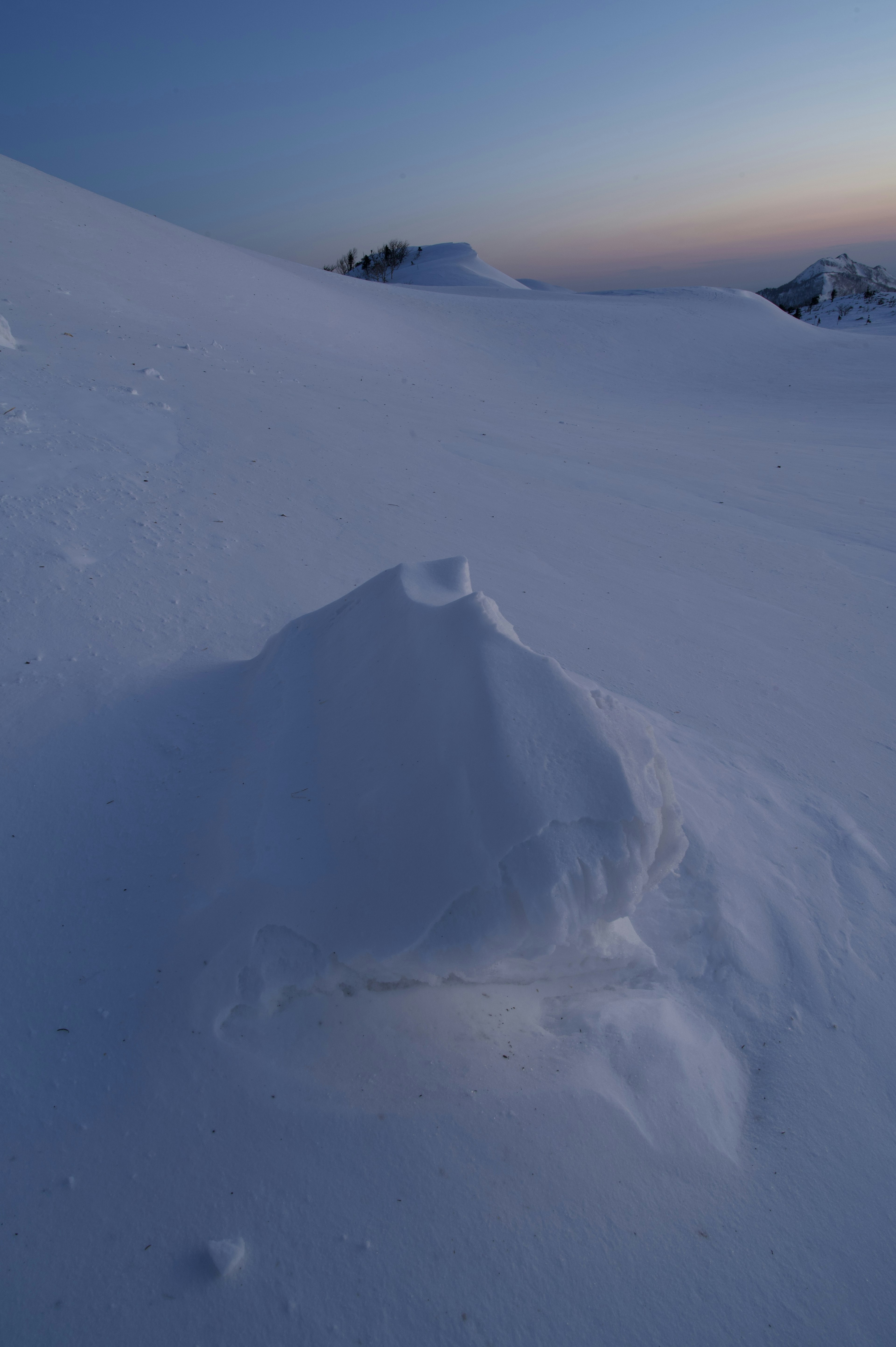 被雪覆盖的小山丘与黄昏天空