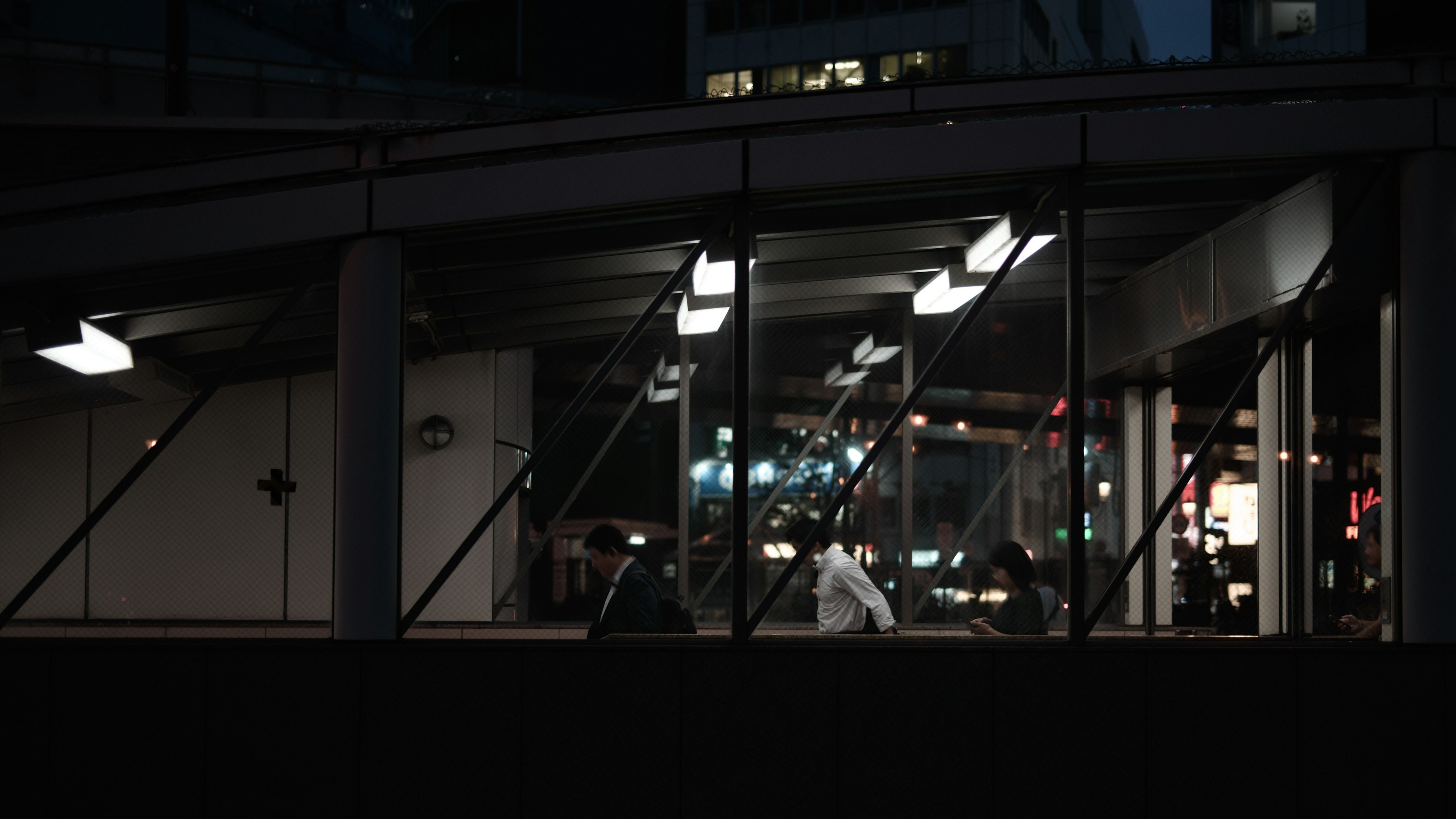 Bâtiment moderne dans un cadre urbain sombre avec circulation extérieure