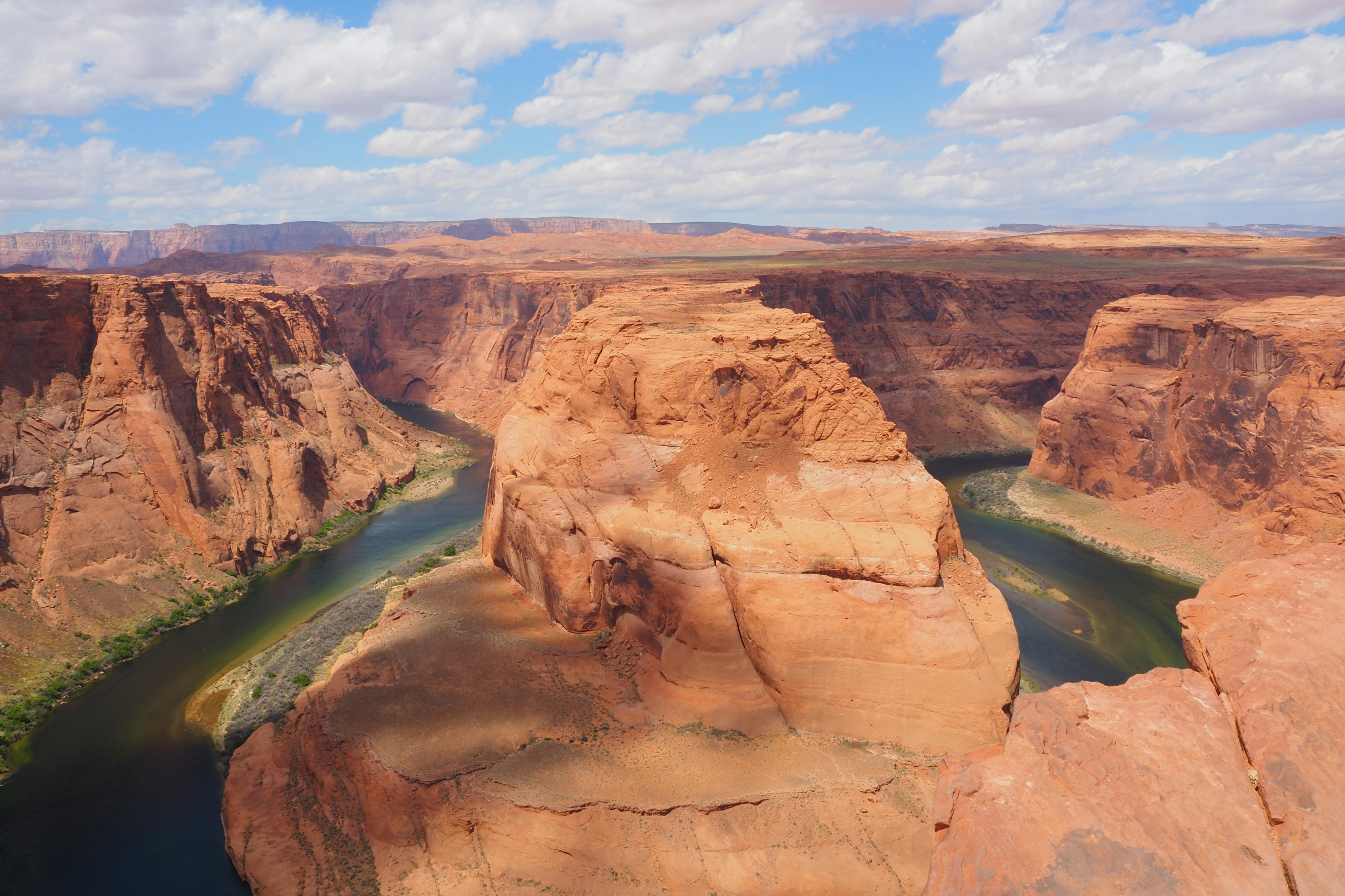 Horseshoe Bend con formaciones rocosas rojas y un río verde en forma de curva