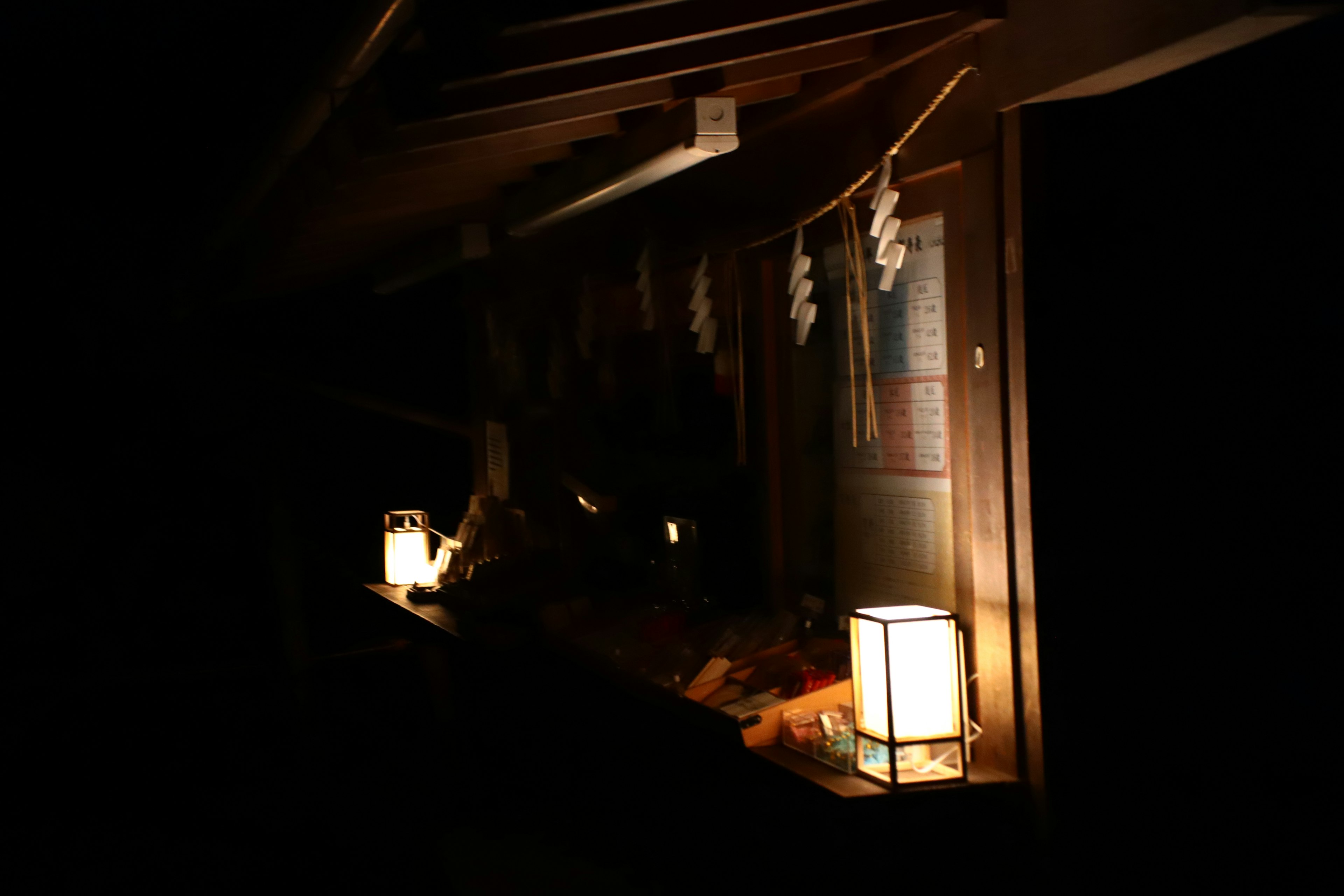 Extérieur d'un bâtiment en bois faiblement éclairé avec des lanternes lumineuses