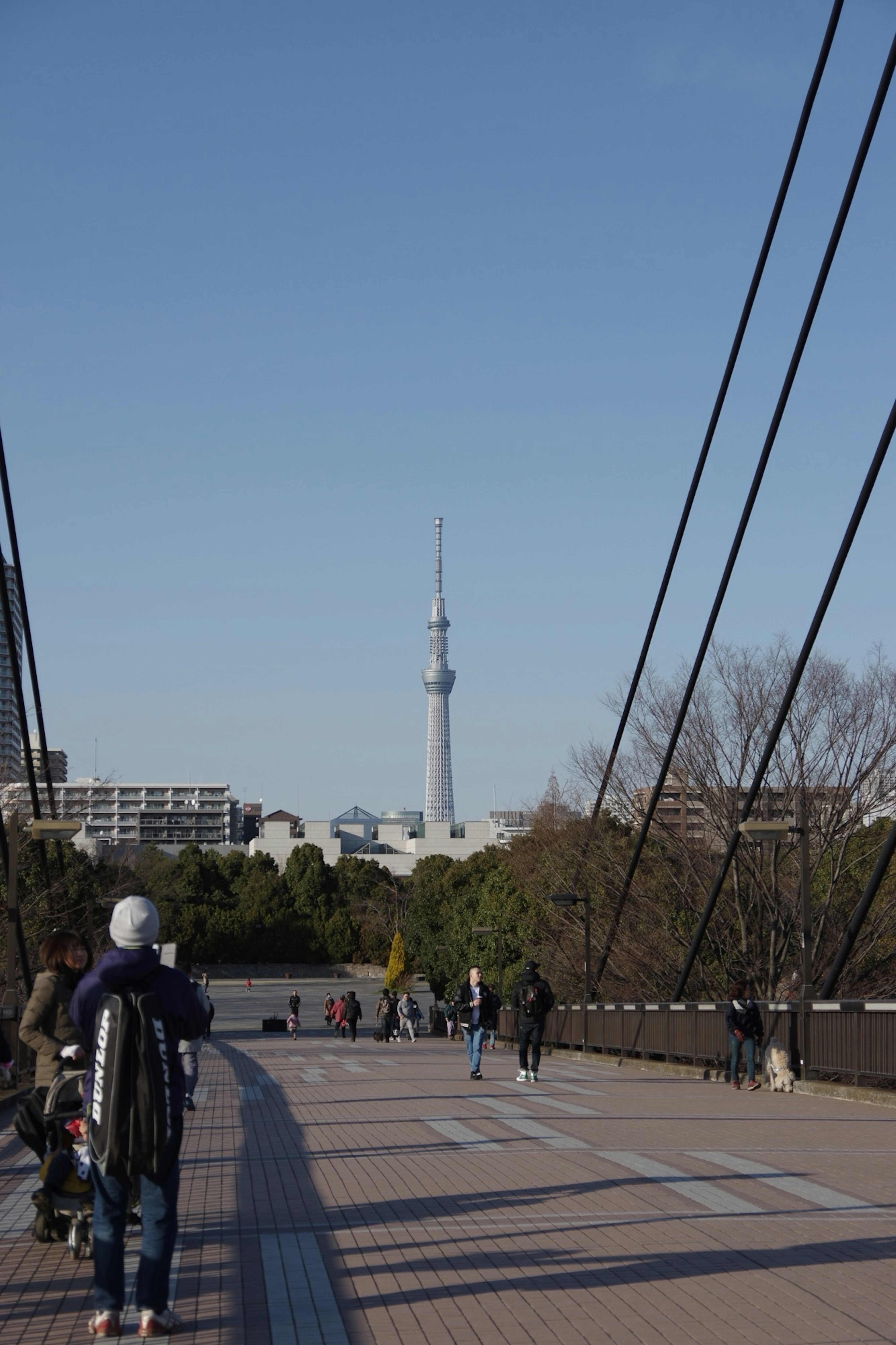 Pemandangan Tokyo Skytree dari jembatan dengan orang-orang berjalan