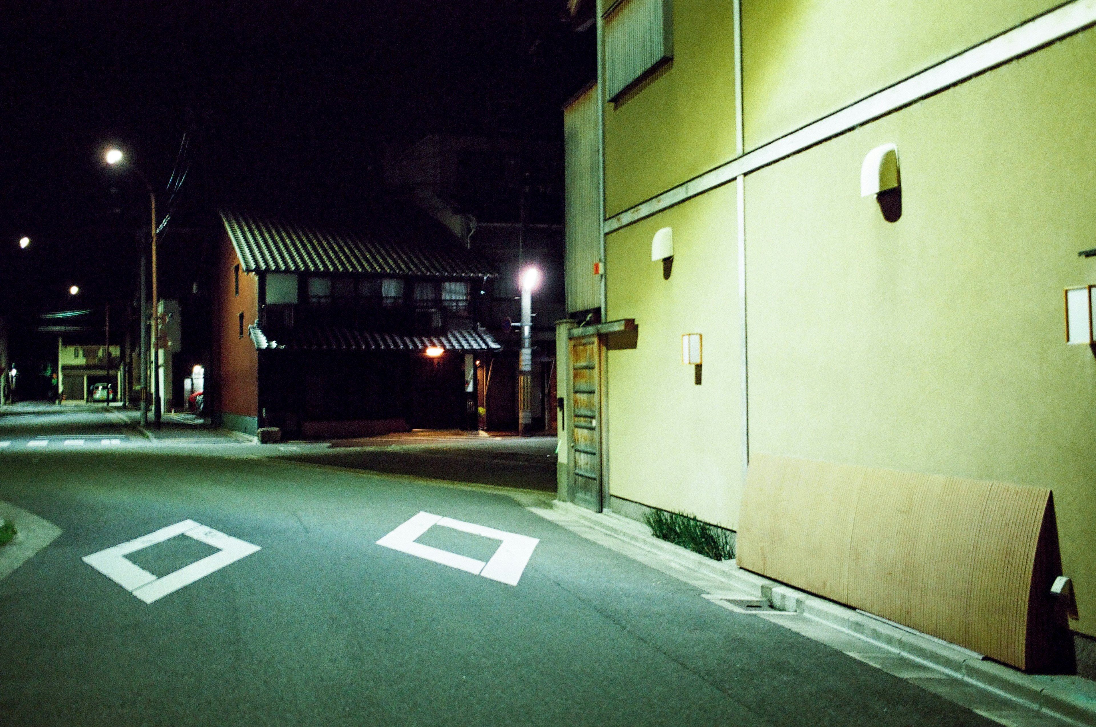 Nighttime street corner scene with quiet road and buildings