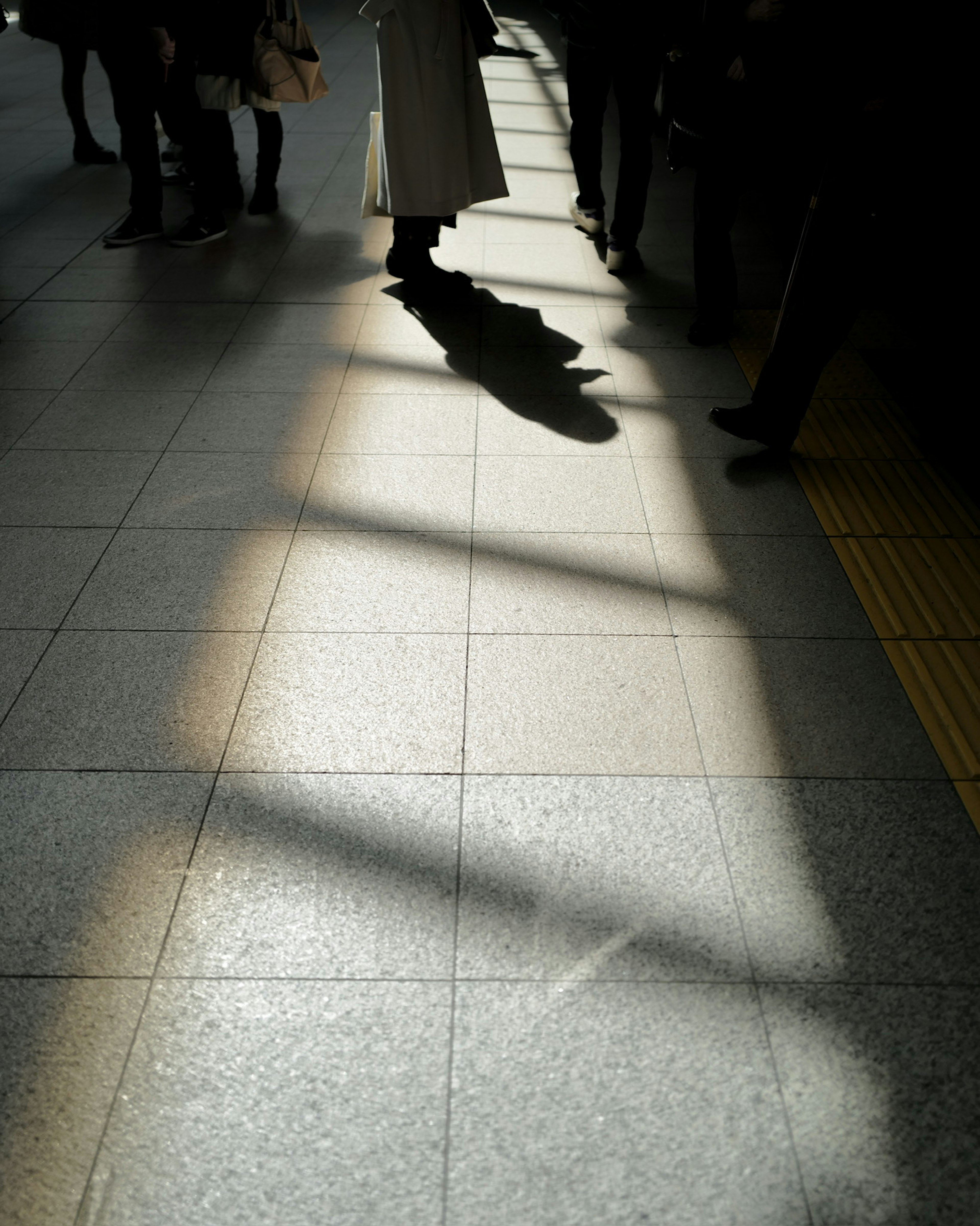 Intersection of light and shadow on a train station floor