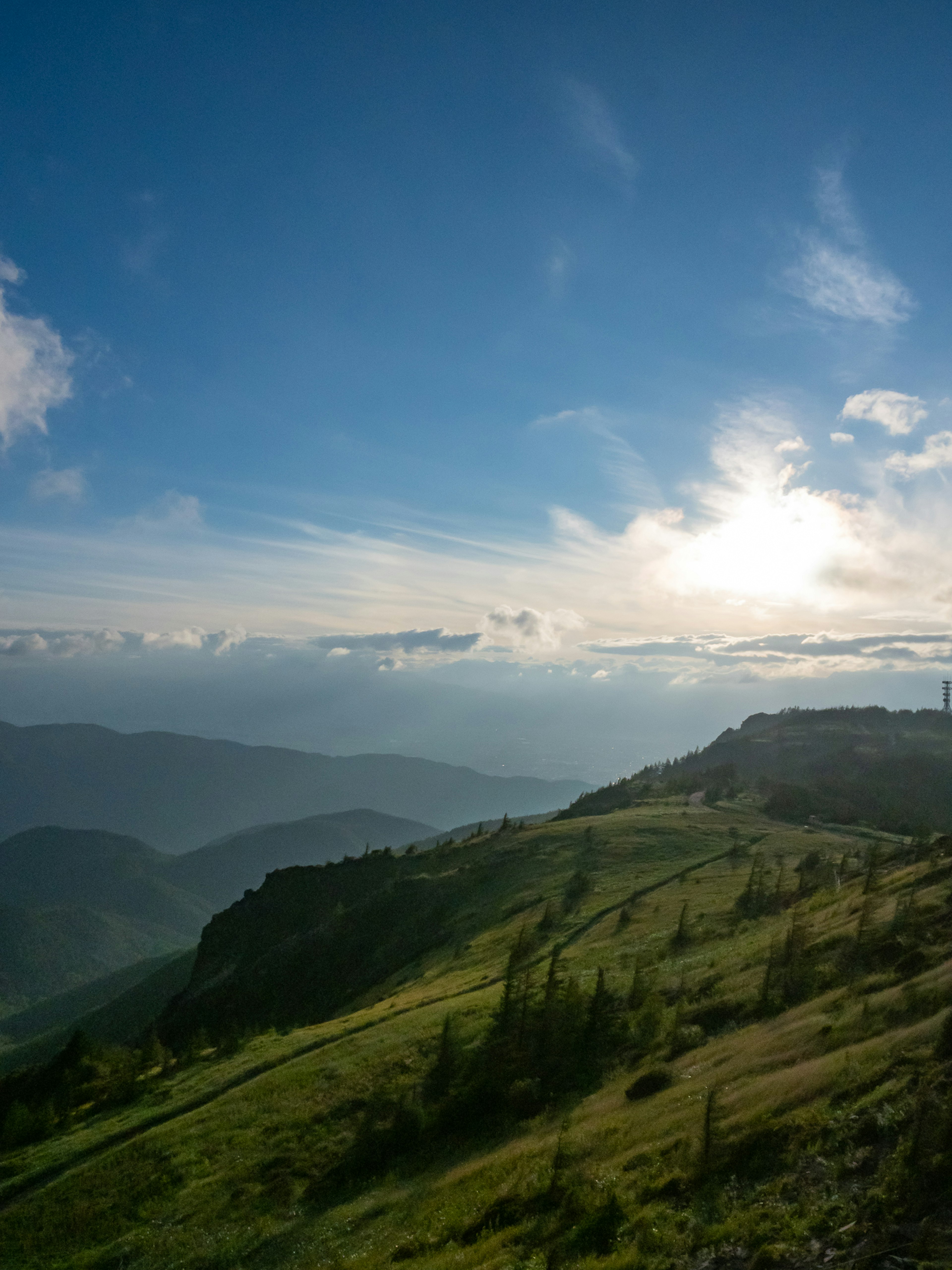 Paysage de montagne avec ciel bleu et nuages collines vertes et montagnes lointaines