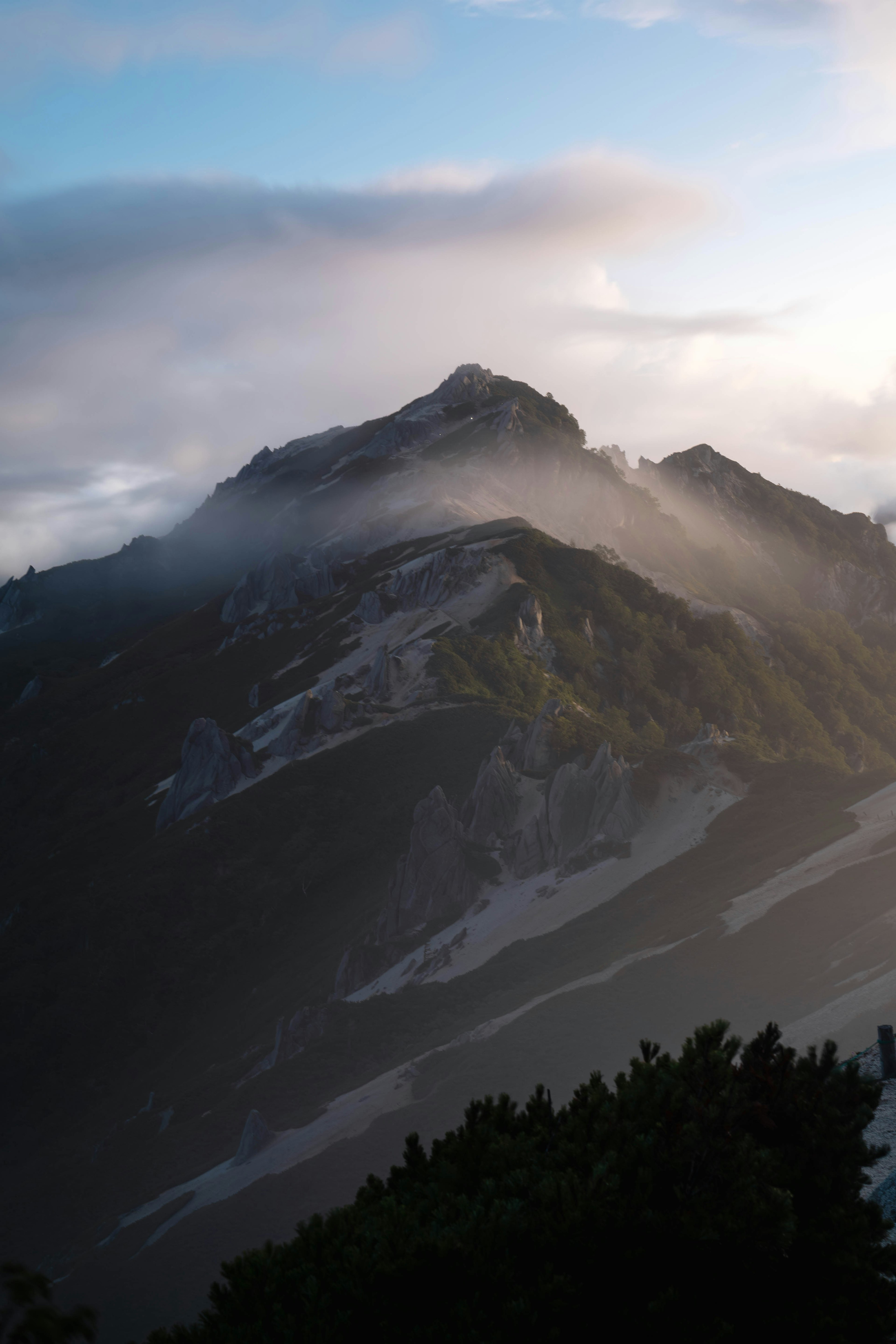 霧に包まれた山の風景　夕暮れの柔らかな光が山を照らす