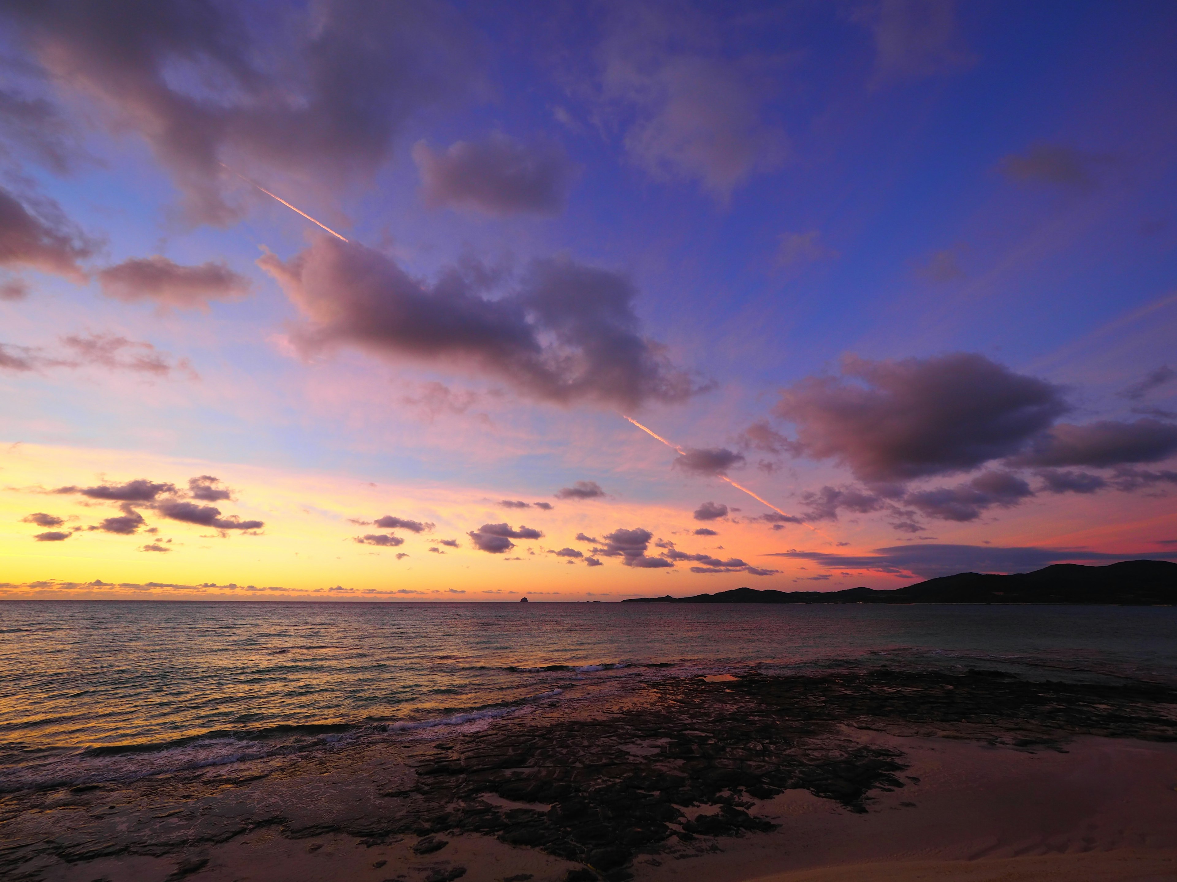 美しい夕焼けの海の風景に広がる雲と水面の反射