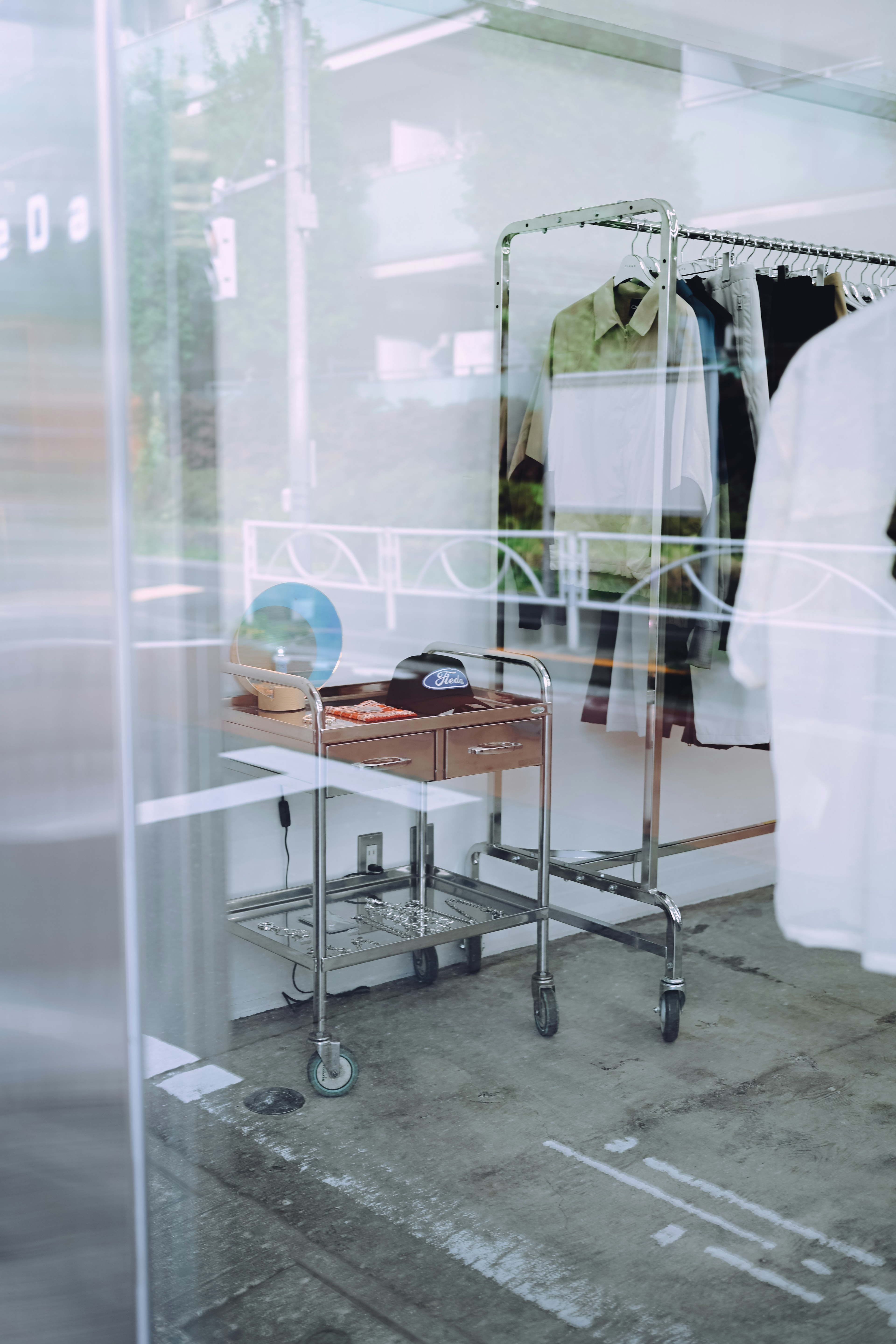 Vêtements exposés derrière une vitre transparente avec une table en bois