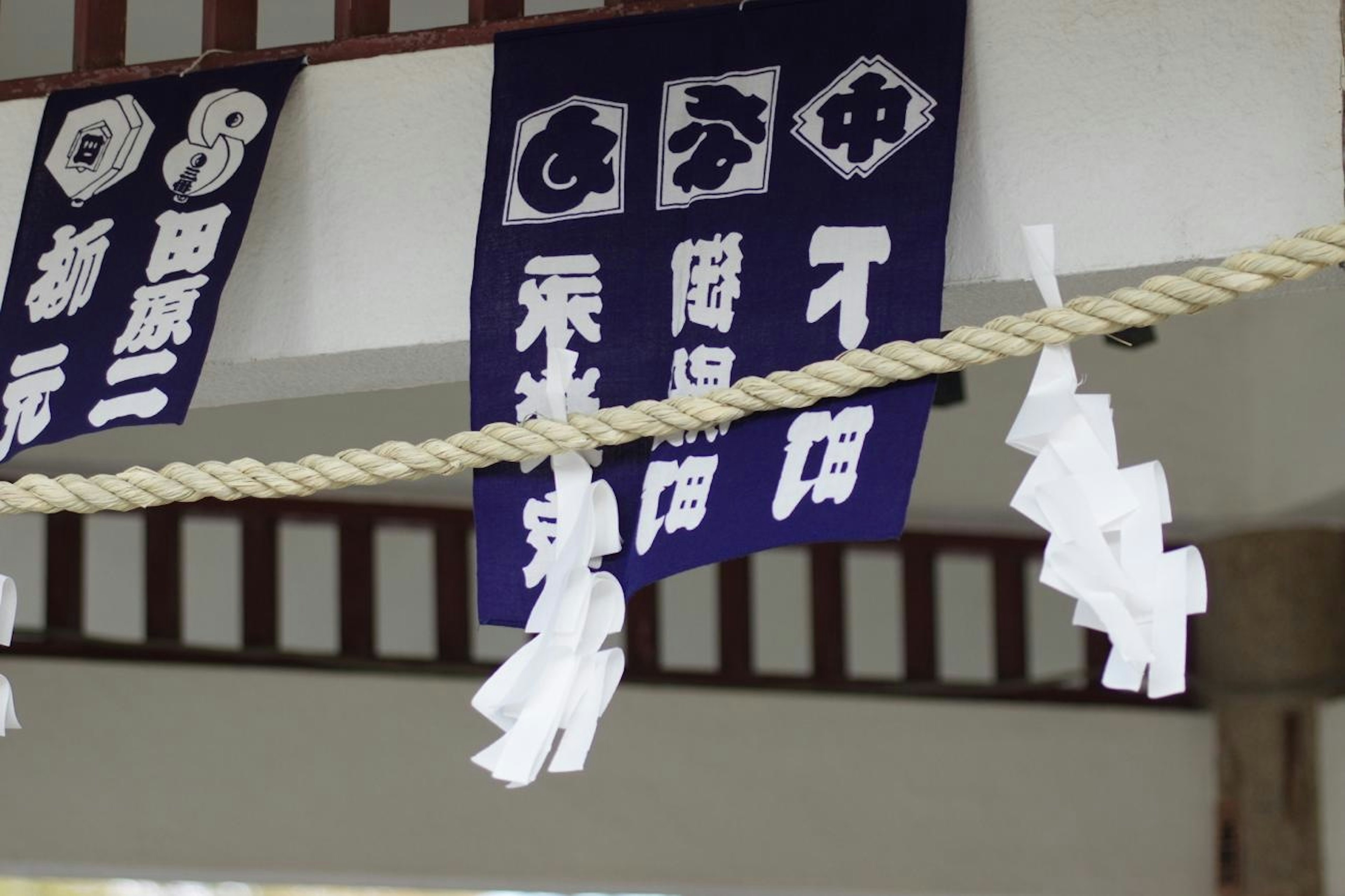 青い旗が吊るされている神社の内部のシーン