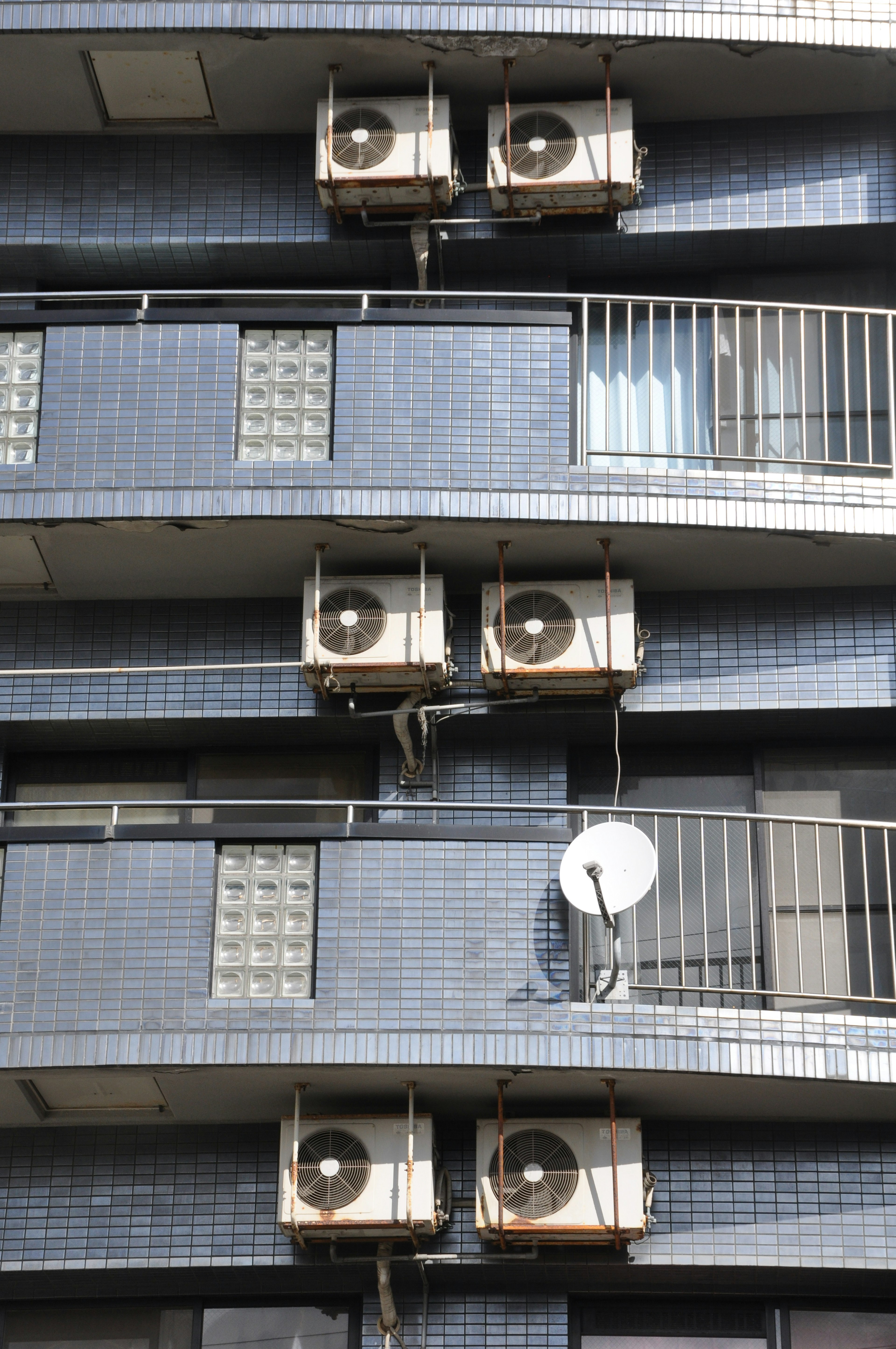 Exterior de un edificio con unidades de aire acondicionado y una antena parabólica