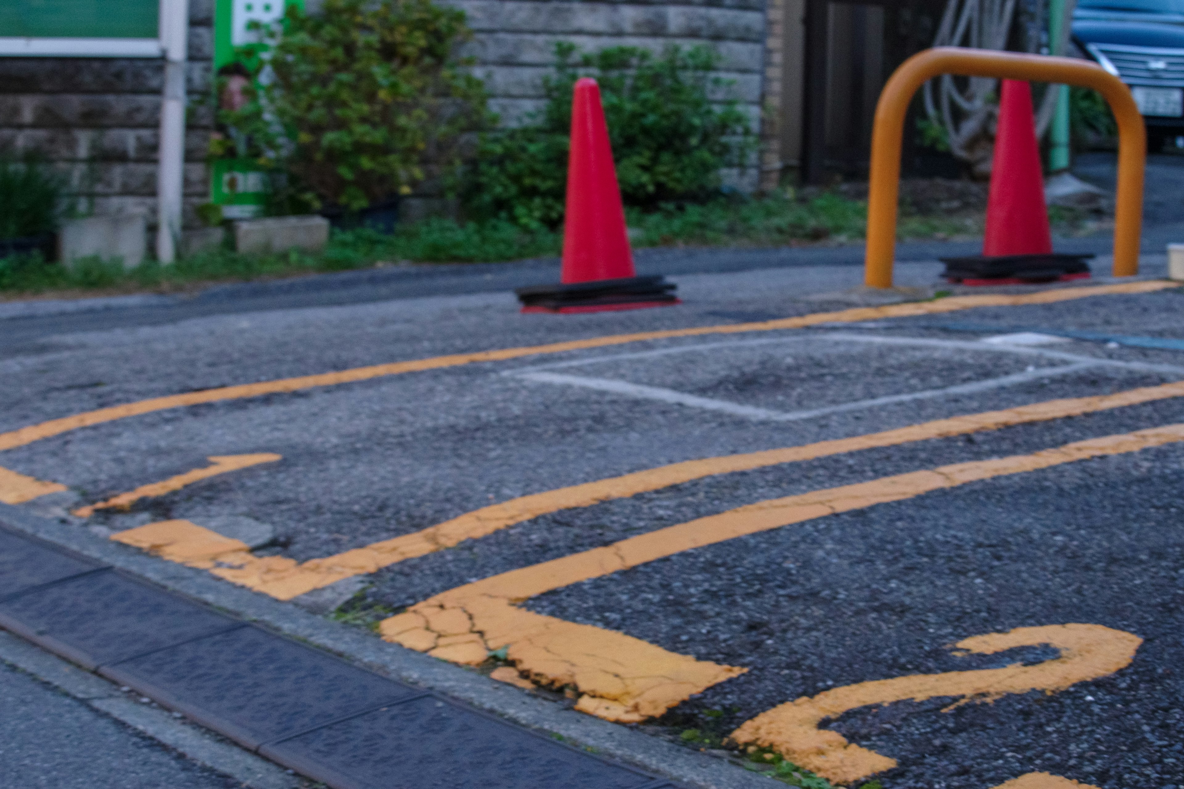 Section of a road with red cones and orange line markings