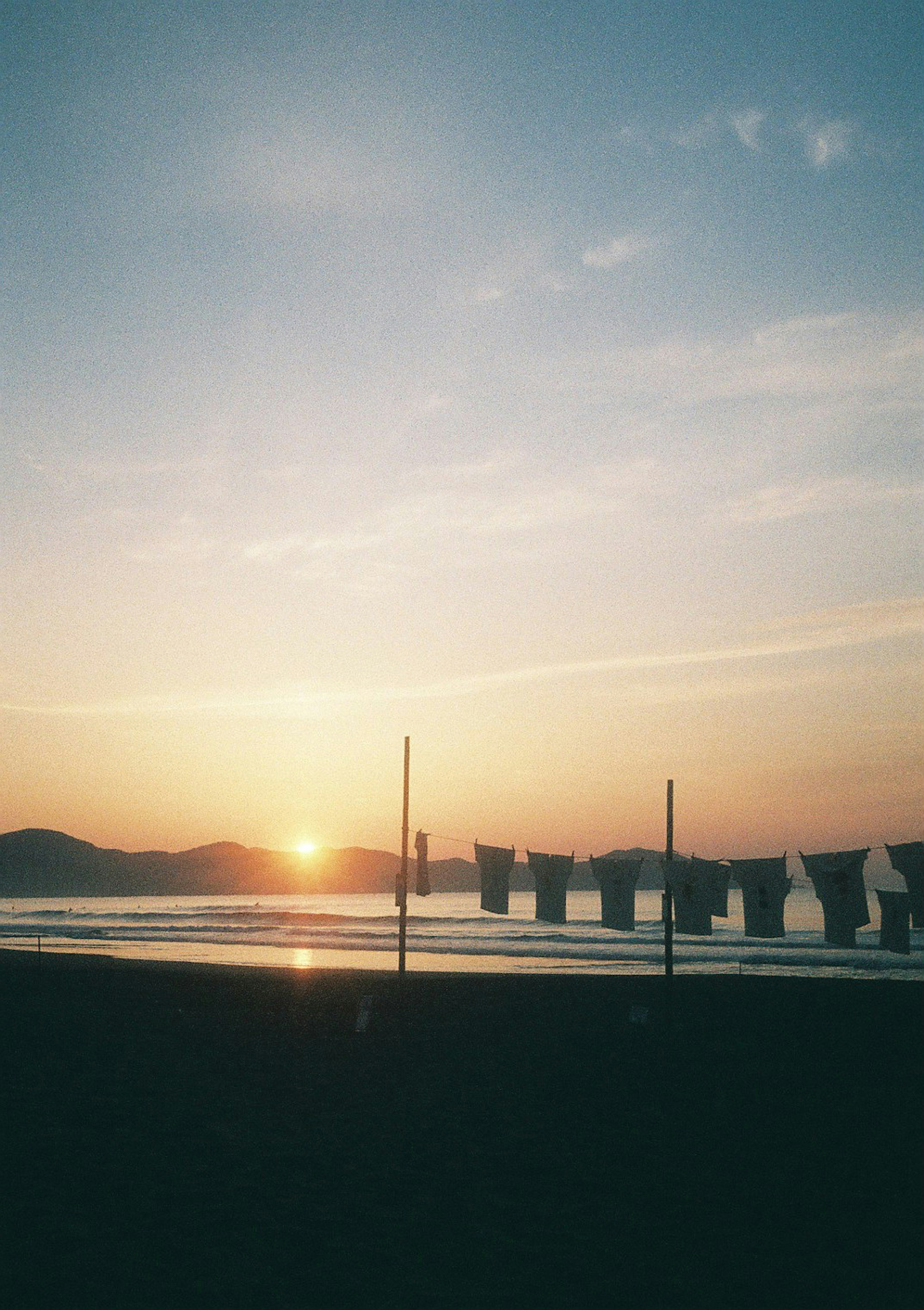 美しい夕日が海に沈む景色と洗濯物が干された風景