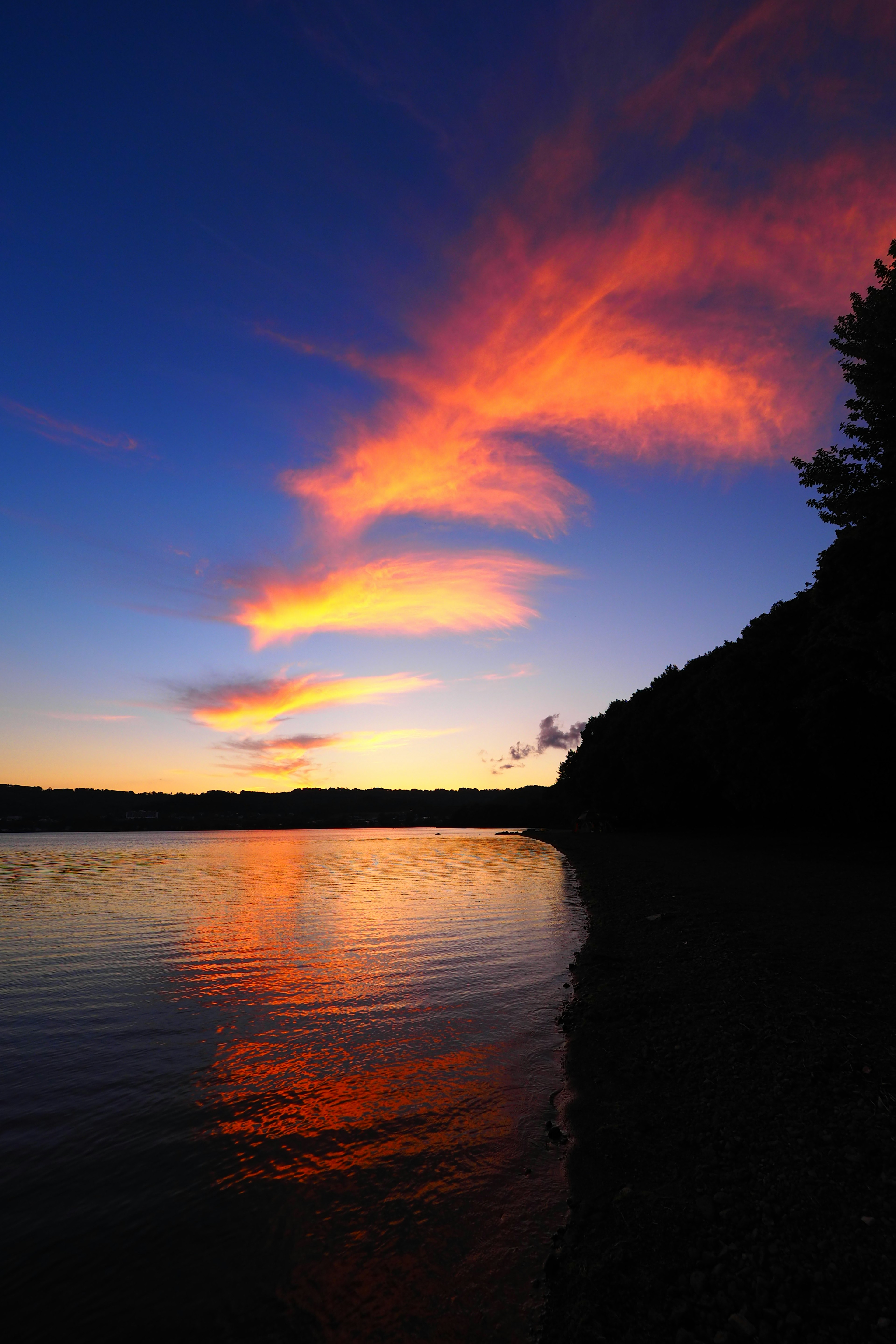 Farbenfrohe Wolken in einem schönen Sonnenuntergangshimmel, der sich auf einem ruhigen See spiegelt