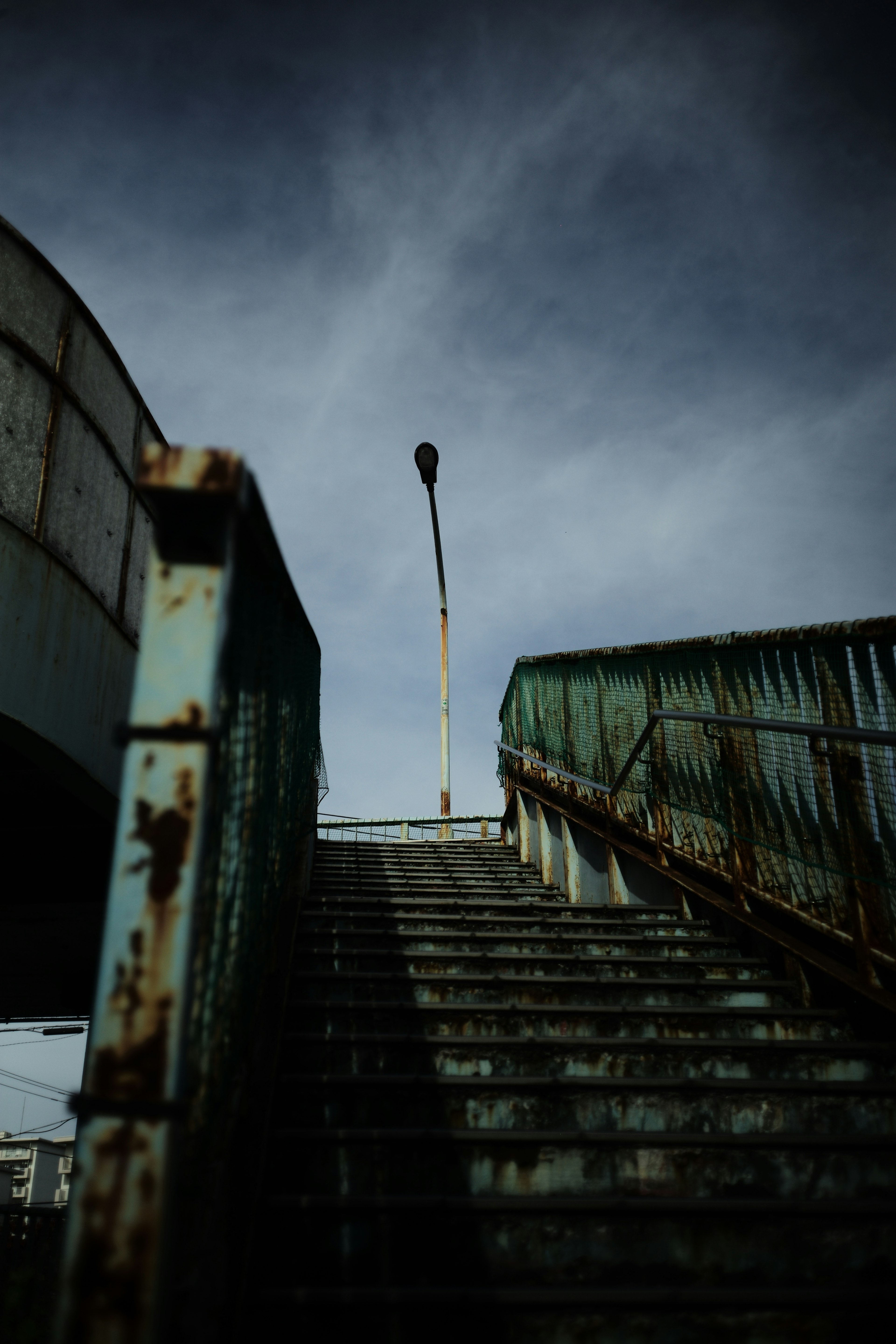 Treppe zu einer Straßenlaterne unter einem bewölkten Himmel