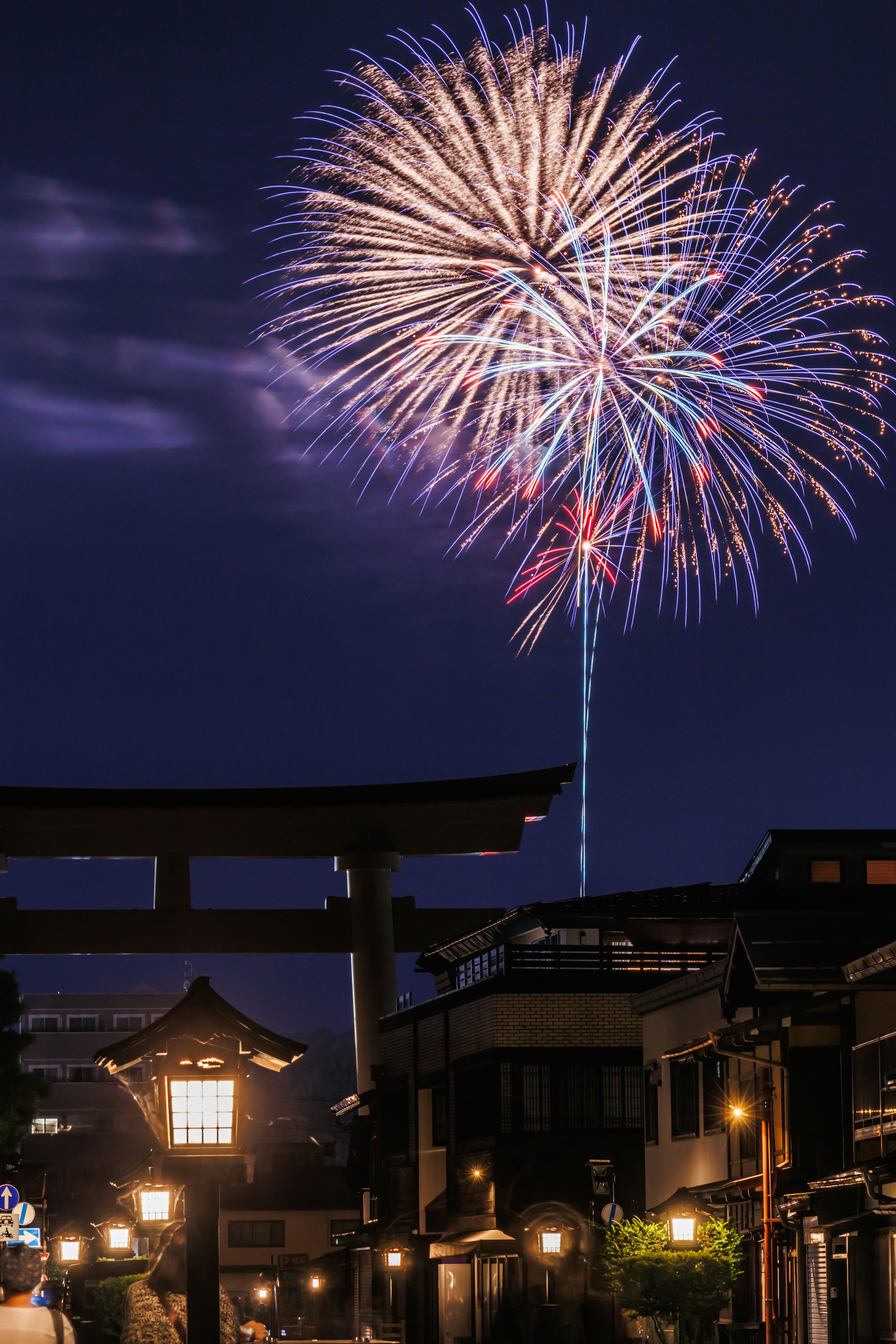 Fuegos artificiales iluminando el cielo nocturno sobre la arquitectura japonesa tradicional