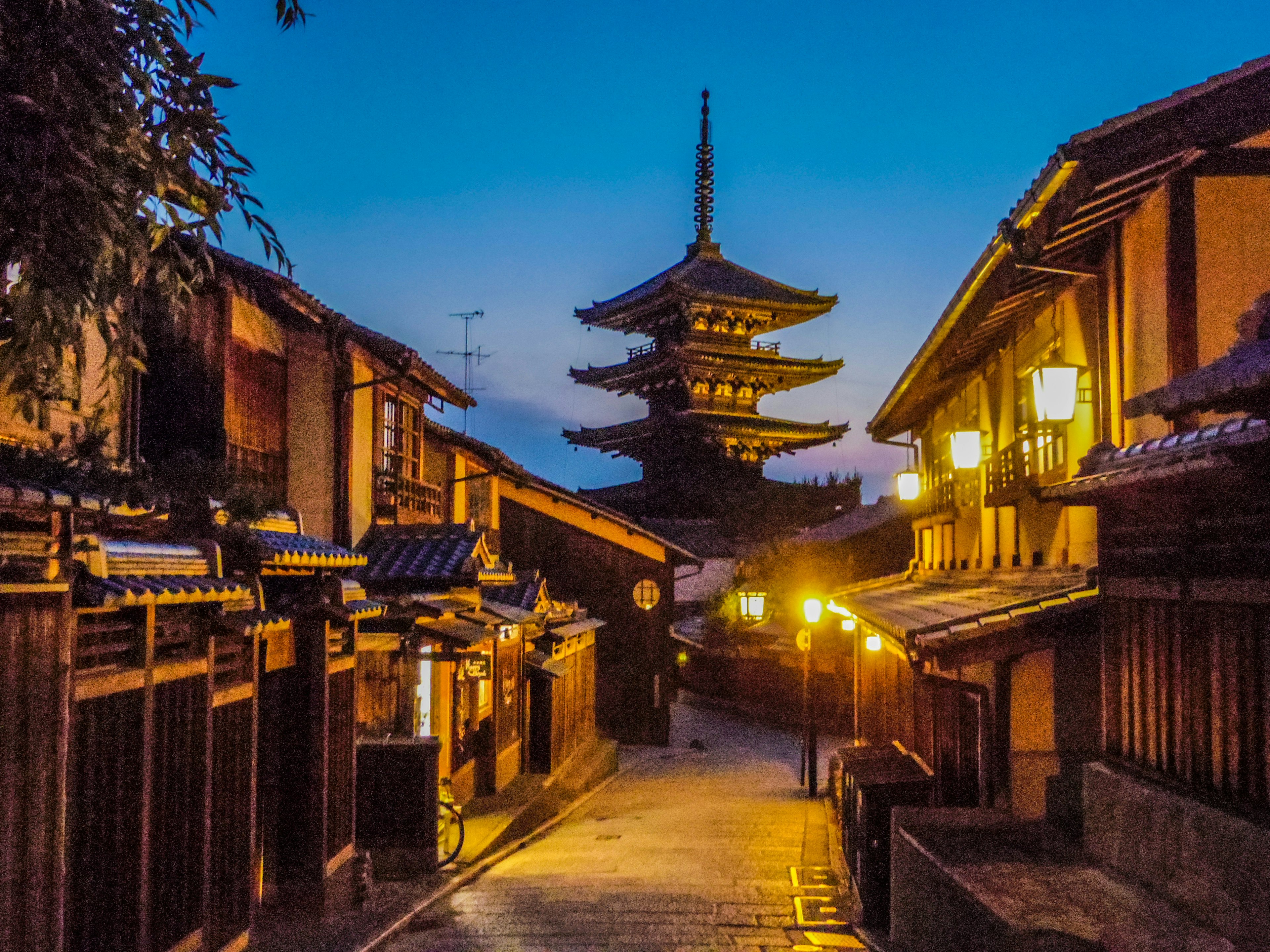 Traditional wooden buildings and a five-story pagoda in Kyoto at night