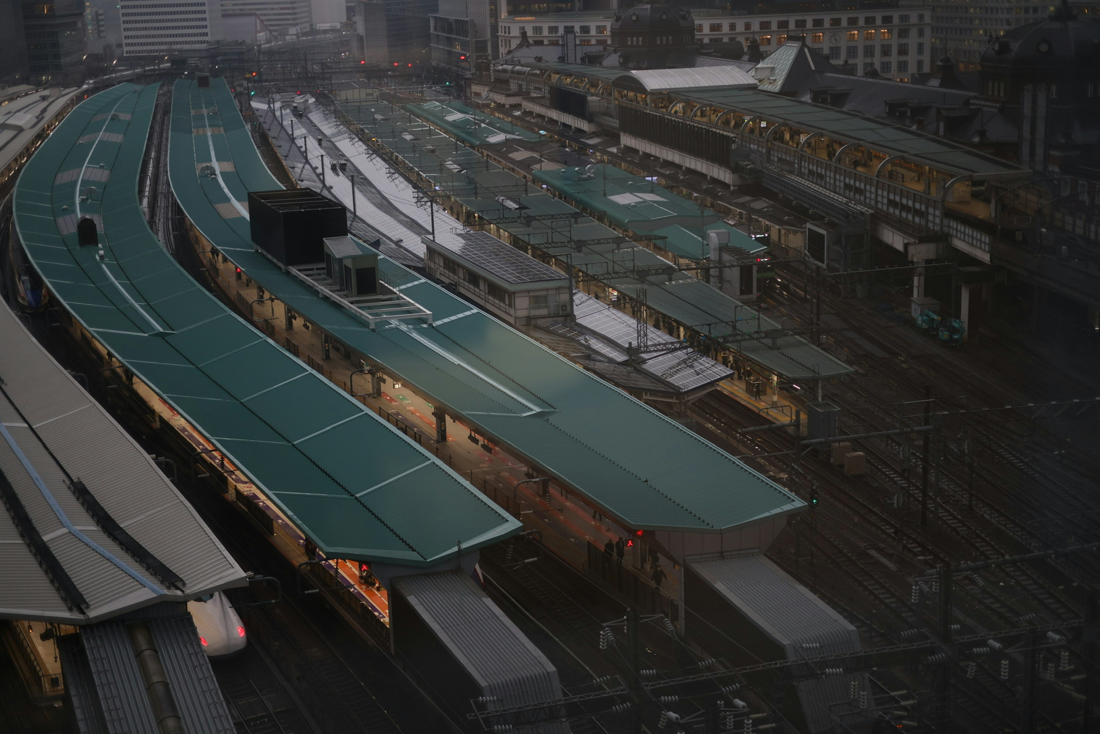 Escena urbana con plataformas de tren elevadas y techos verdes